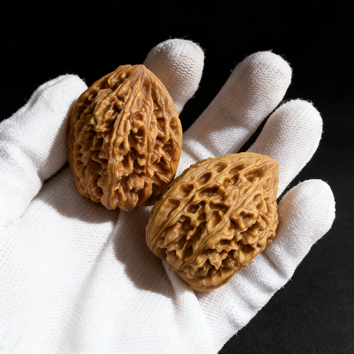 Pair of walnut hand exercisers called Imperial Heart with tall silhouette and deep honeycomb texture, 36mm size by ThePatinaProject.