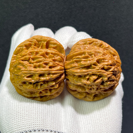 Pair of walnut lion's head hand exercisers from ThePatinaProject, 43mm x 40mm, featuring detailed carved lion's head designs.
