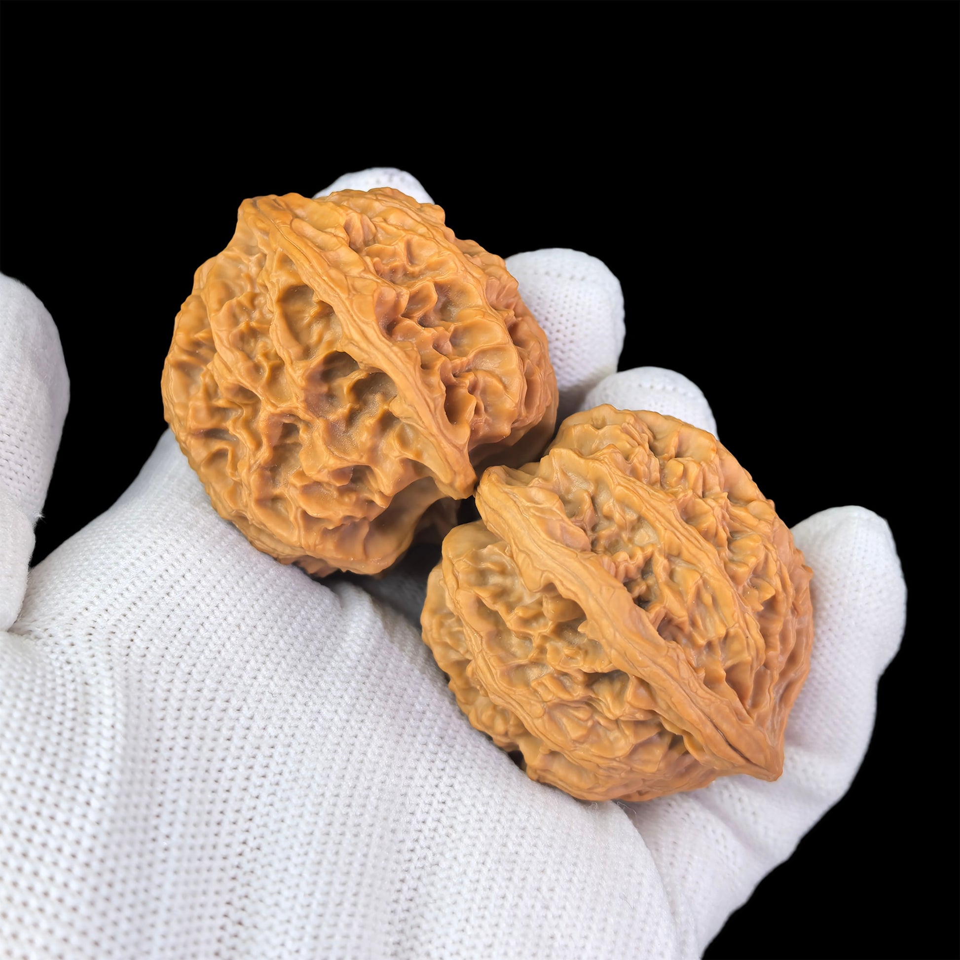 Pair of walnut hand exercisers shaped like lion heads with a 43mm diameter, from ThePatinaProject's Apple Round collection.