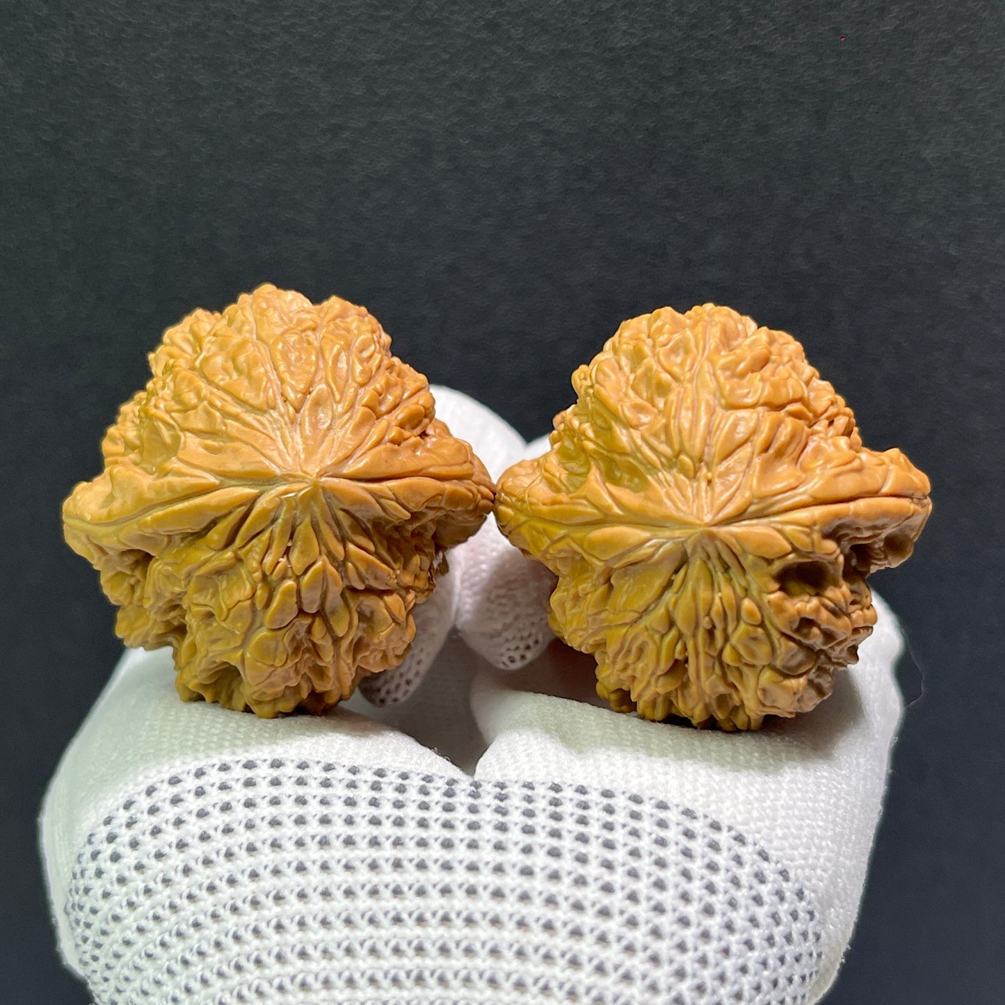 Walnut hand exerciser pair called Blizzard by ThePatinaProject, 41mm x 40mm, with textured walnut surface for grip and finger exercises.