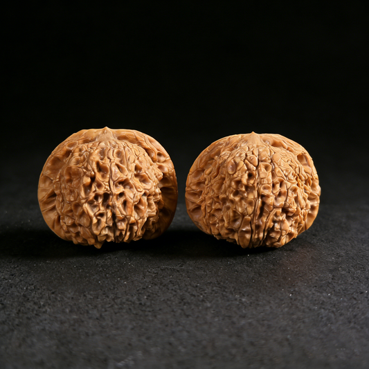 Walnut hand exerciser pair featuring "Blood Kirin" design with thick edges and shredded texture from ThePatinaProject.