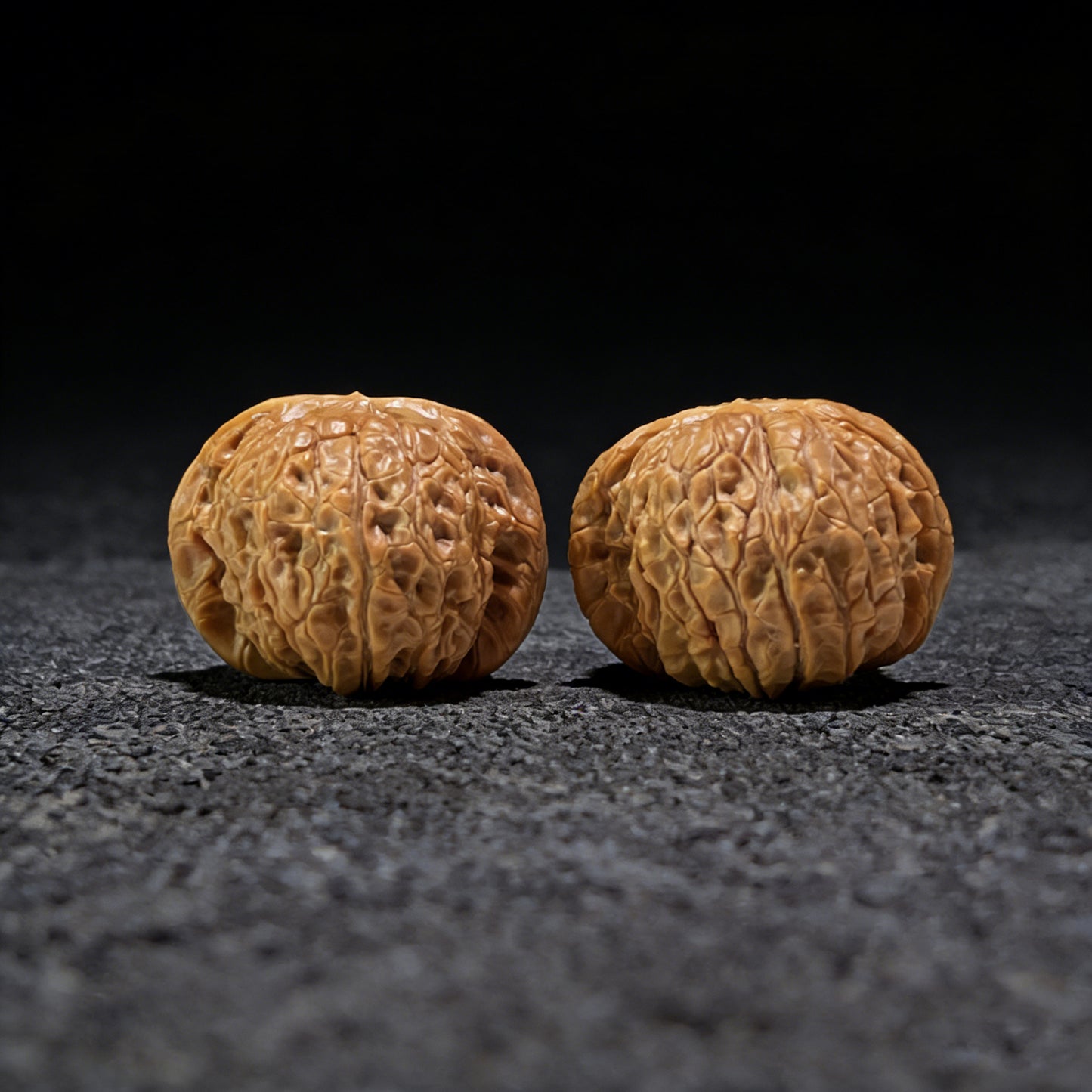 Pair of Blood Qilin walnut hand exercisers from ThePatinaProject, 37mm x 39mm, featuring intricate carved designs.