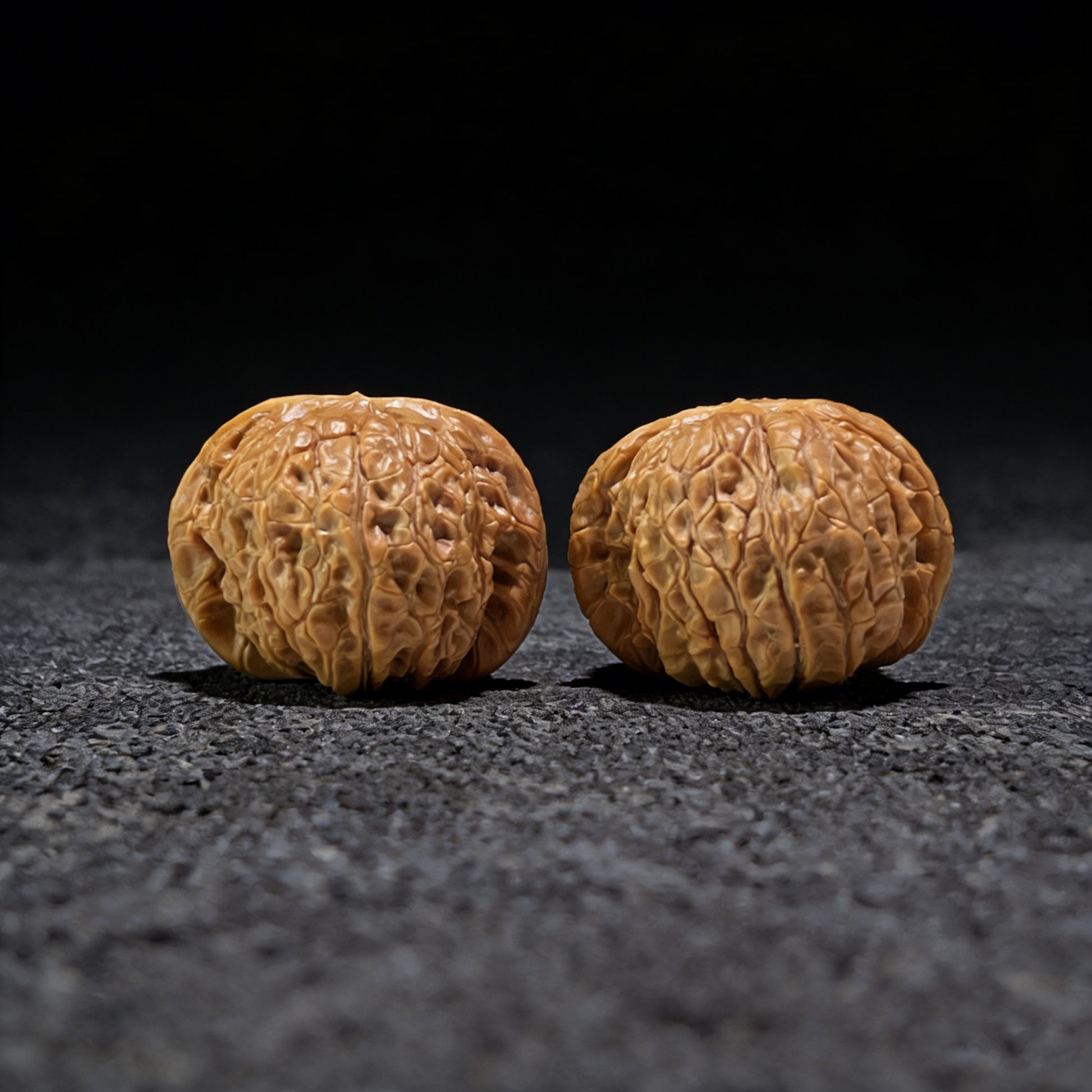 Pair of Blood Qilin walnut hand exercisers from ThePatinaProject, 37mm x 39mm, featuring intricate carved designs.