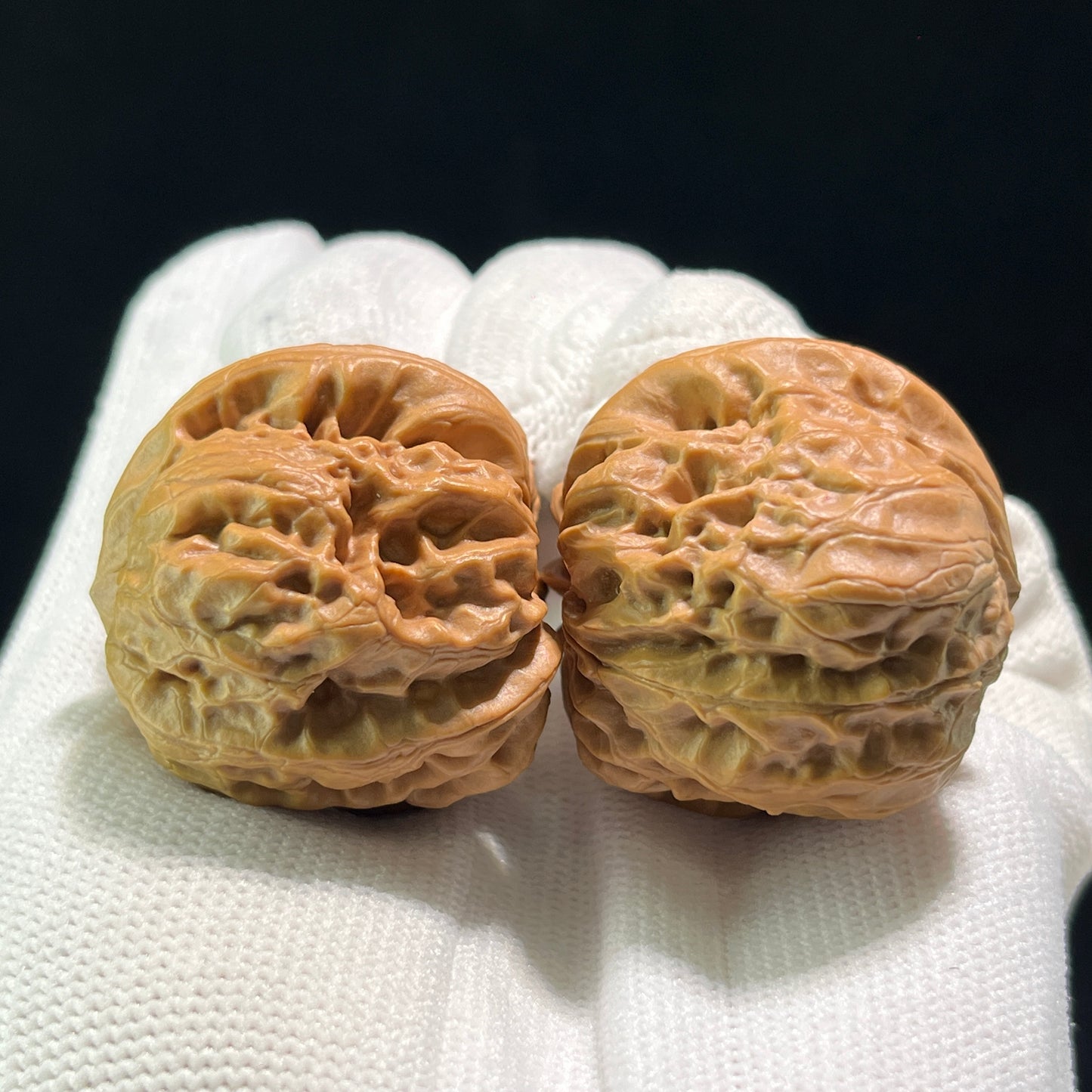 Pair of walnut hand exercisers labeled DM-601 with 36mm x 35mm dimensions, designed for grip strengthening and hand therapy.