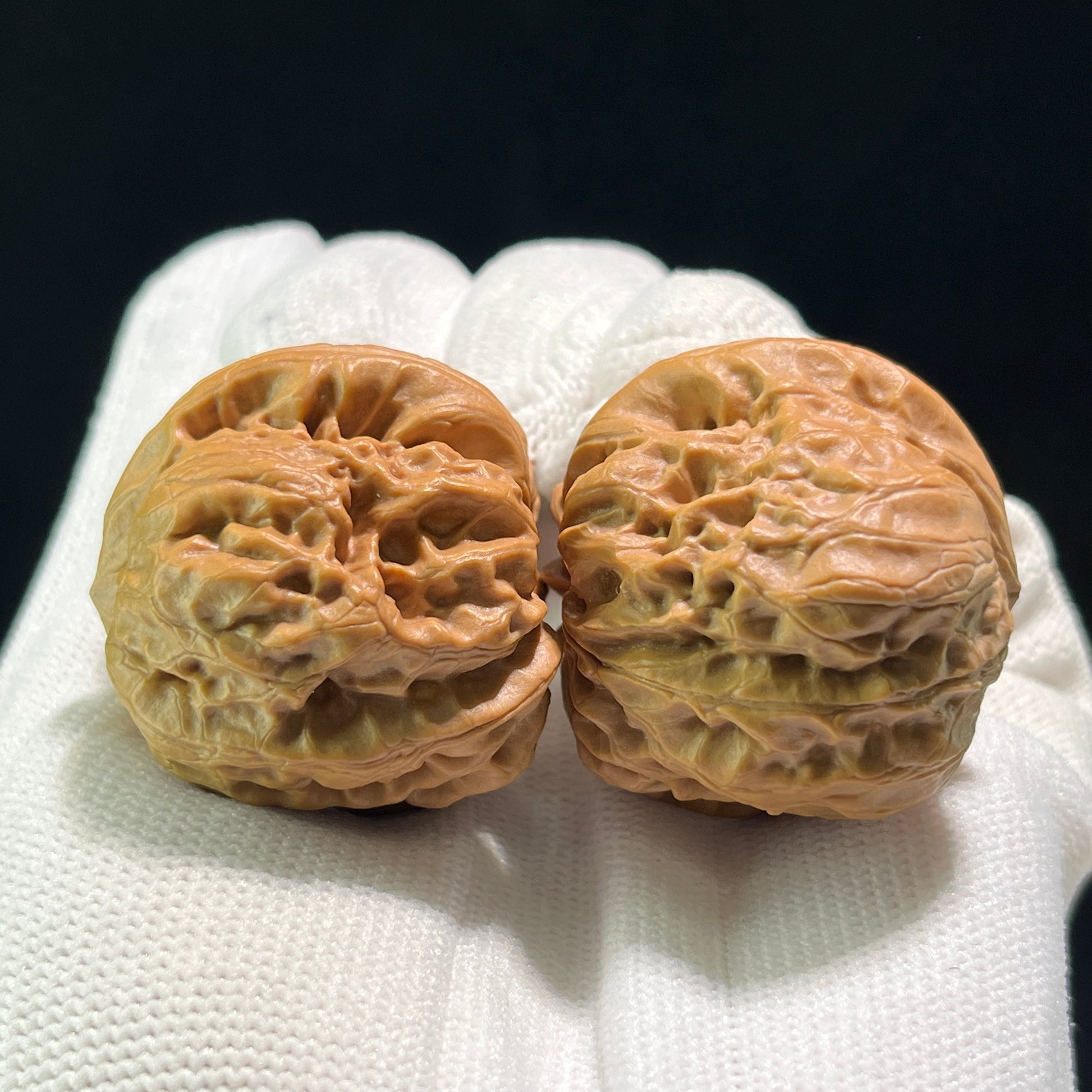 Pair of walnut hand exercisers labeled DM-601 with 36mm x 35mm dimensions, designed for grip strengthening and hand therapy.