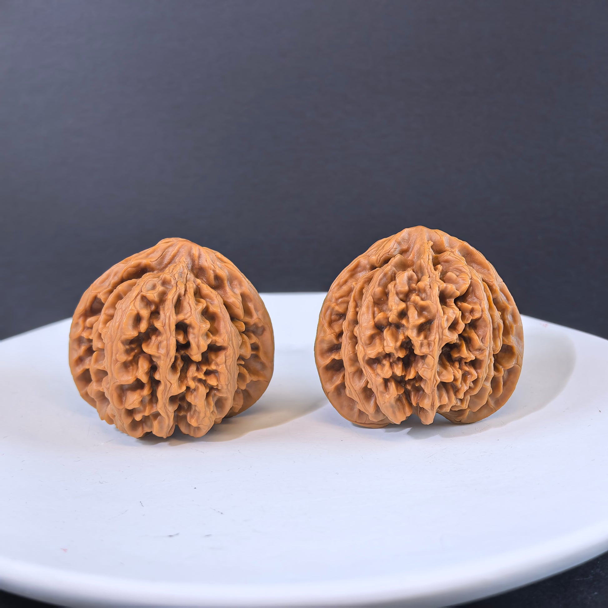 Pair of 43mm walnut hand exercisers from ThePatinaProject's Champion's Crown collection, featuring polished wooden grips for hand strength.