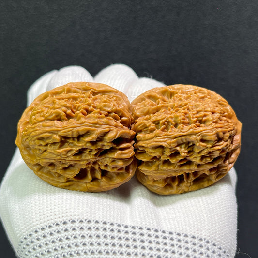 Walnut hand exercisers by ThePatinaProject, classic NJS Balanced 1:1 pair, 38mm x 38mm, showing textured wooden grips and ergonomic design.