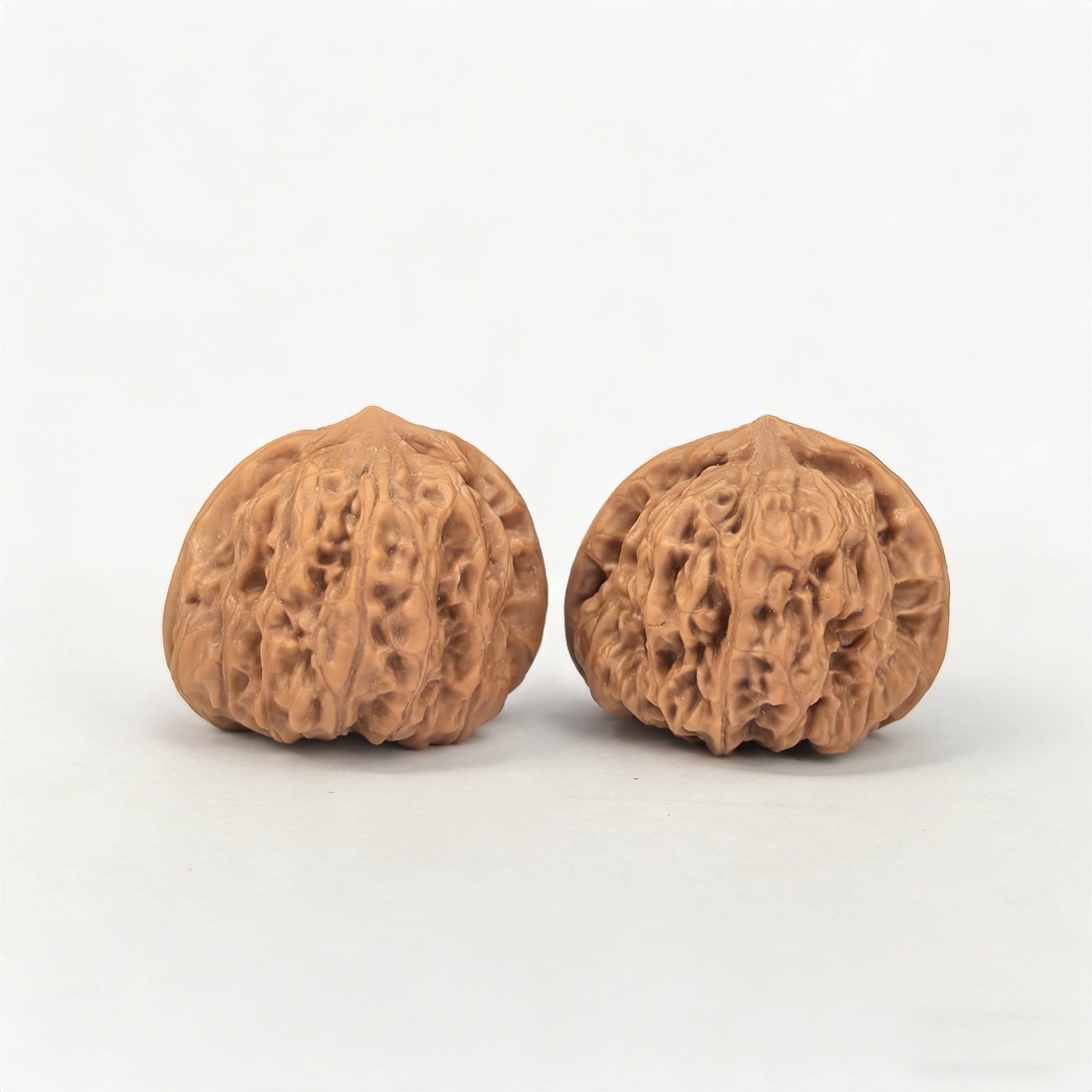 Walnut hand exercisers pair with yuanbao design, 32mm x 31mm, by ThePatinaProject, showing textured wood surface and unique shape.