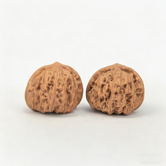 Walnut hand exercisers pair with yuanbao design, 32mm x 31mm, by ThePatinaProject, showing textured wood surface and unique shape.