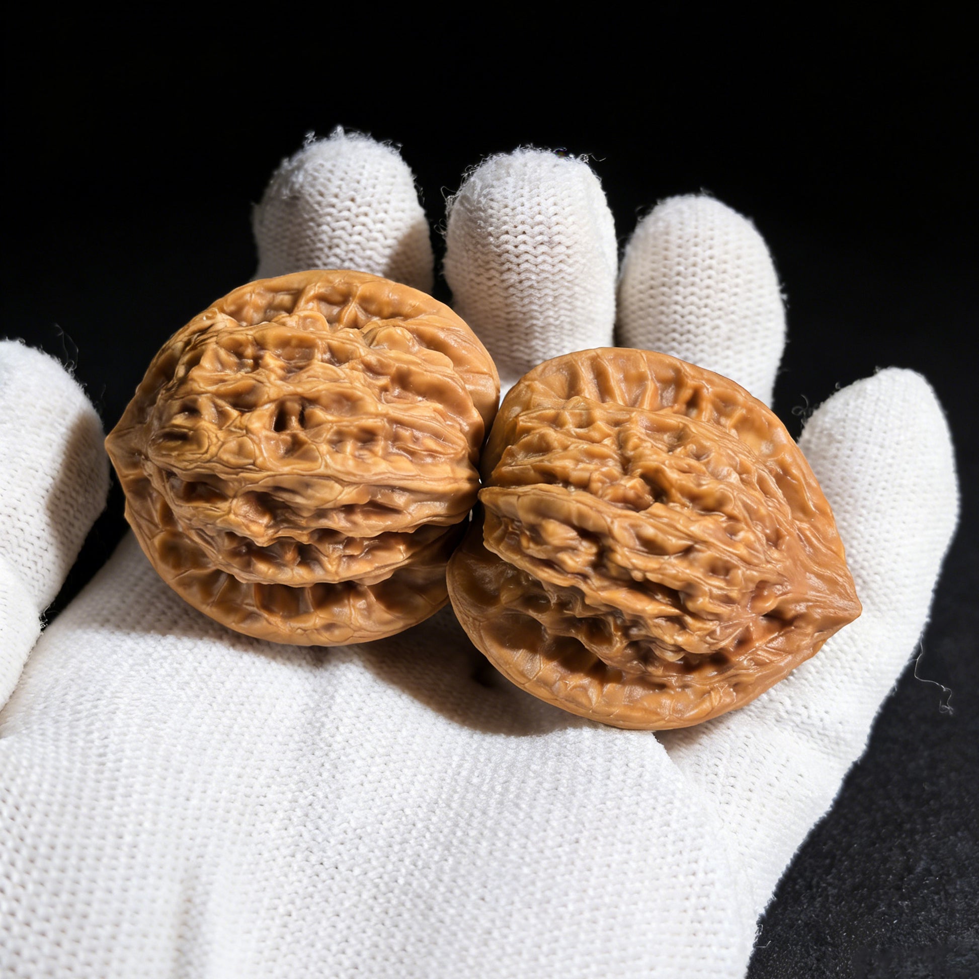Pair of walnut hand exercisers called Gentleman’s Hat (Gongzi Mao) by ThePatinaProject, measuring 37mm by 32mm.