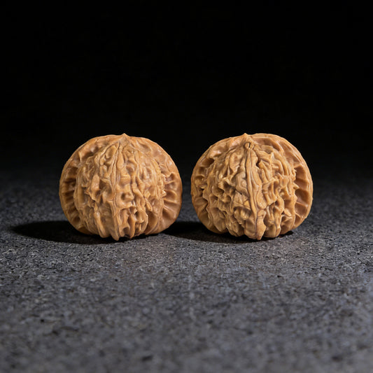 Walnut hand exerciser pair "Hidden Tip White Lion" by ThePatinaProject, 39mm x 37mm, showcasing intricate carved details.