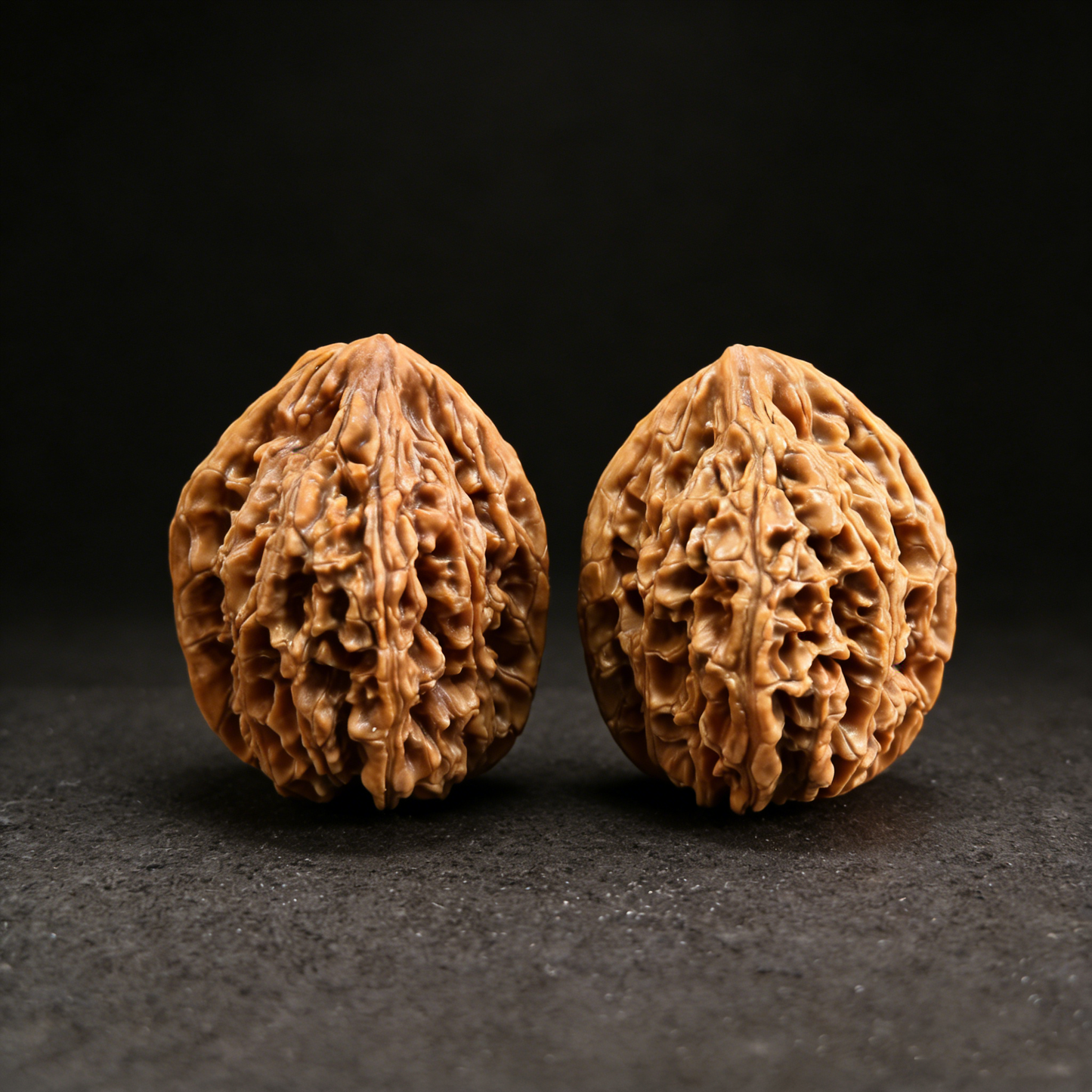 Pair of Walnut hand exercisers labeled "Imperial Heart" with tall silhouette and deep honeycomb texture, 36mm size from ThePatinaProject.