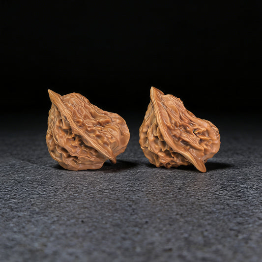 Pair of Walnut Hand Exercisers called Irregular Little Bird by ThePatinaProject, with textured surfaces and ergonomic shape.