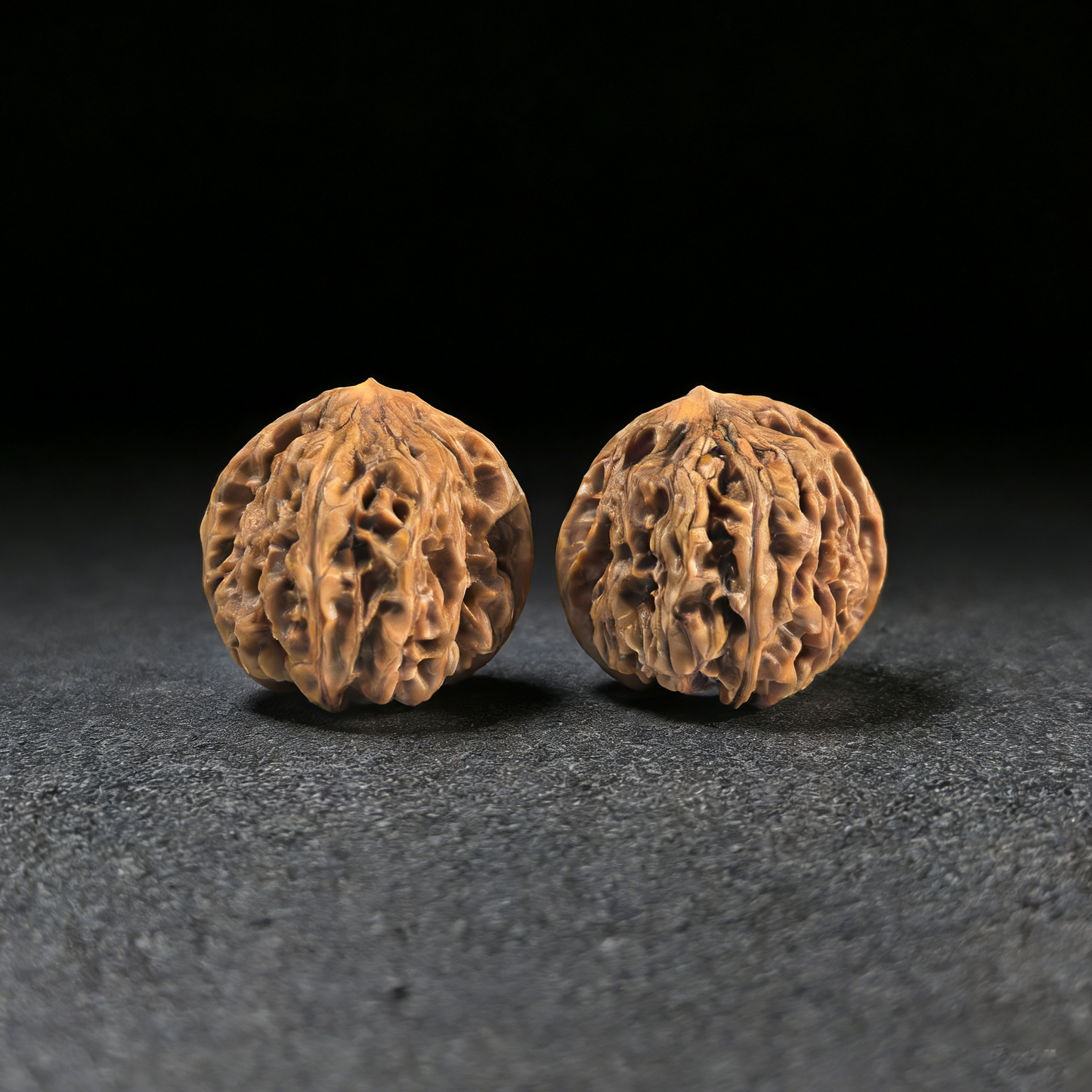 Walnut hand exercisers from ThePatinaProject, "Jiu Long Yu" Nine Dragons Valley pair, 40mm size, showcasing textured wood grips.