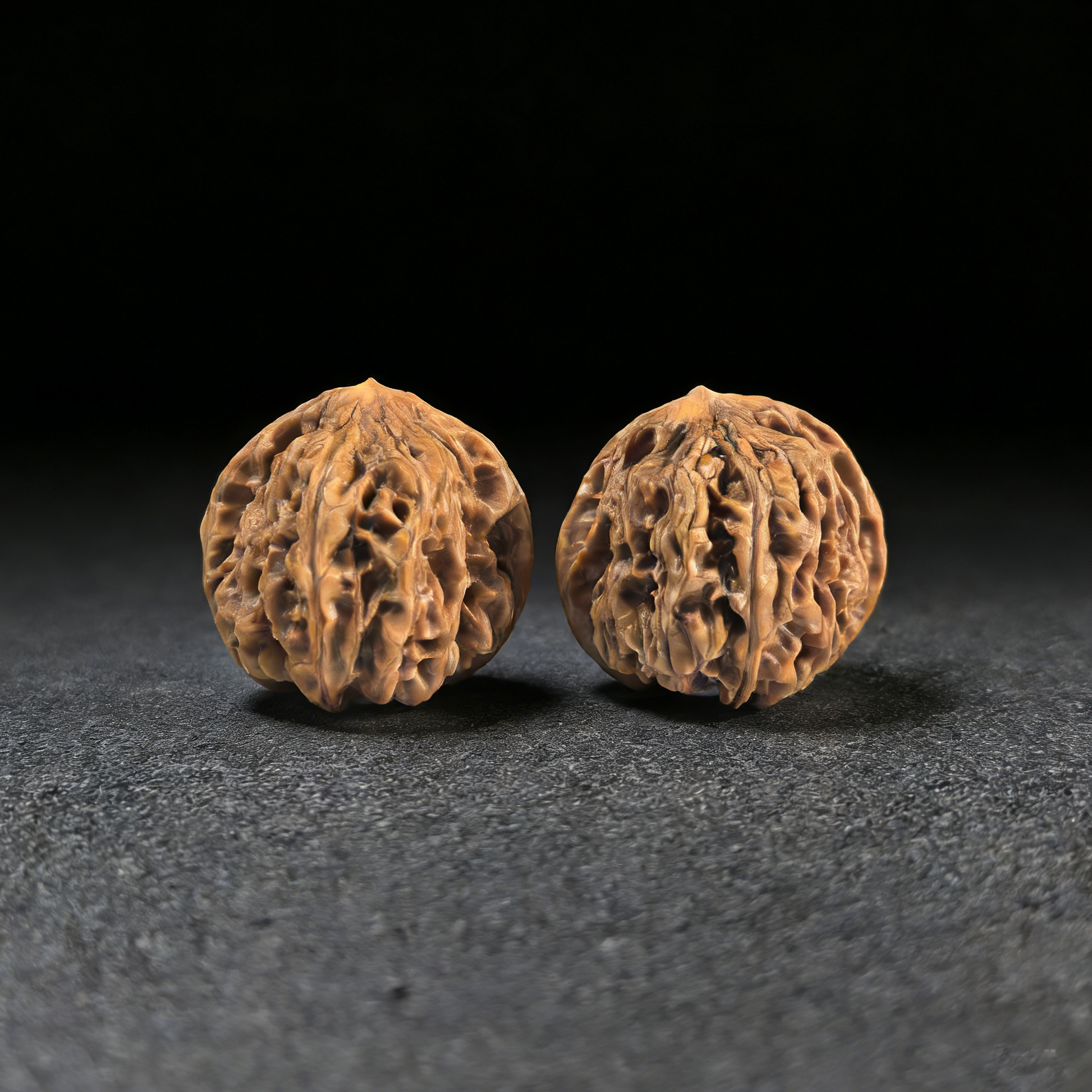 Walnut hand exercisers from ThePatinaProject, "Jiu Long Yu" Nine Dragons Valley pair, 40mm size, showcasing textured wood grips.