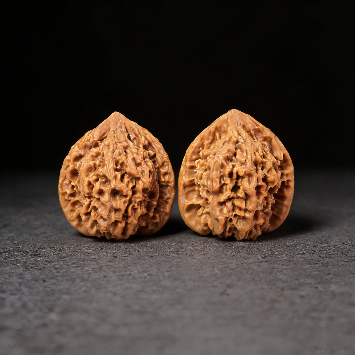 Walnut hand exerciser pair with large official's hat design, 45mm x 40mm, by ThePatinaProject, featuring detailed carved pattern.