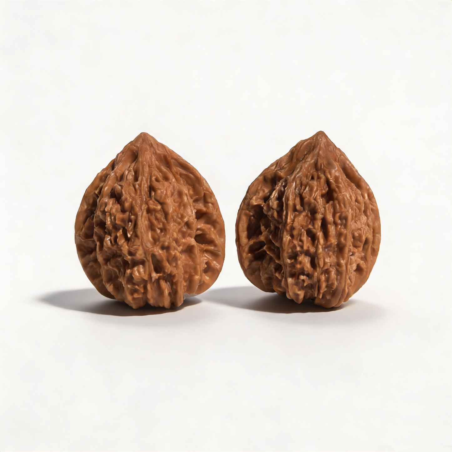 Hand exercising walnut pair with starry "Meteor Shower" texture and heart-shaped design, 37mm size by ThePatinaProject