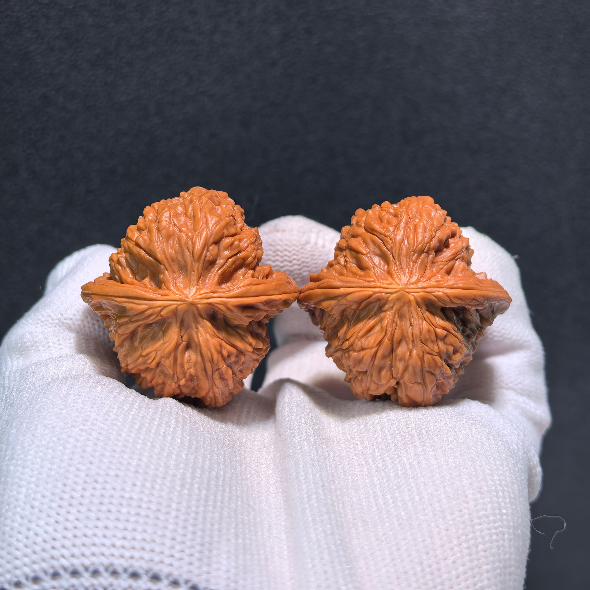 Walnut hand exercisers called Millstone (Mo Pan) pair, 37mm x 37mm, from ThePatinaProject, showing textured wooden grips.