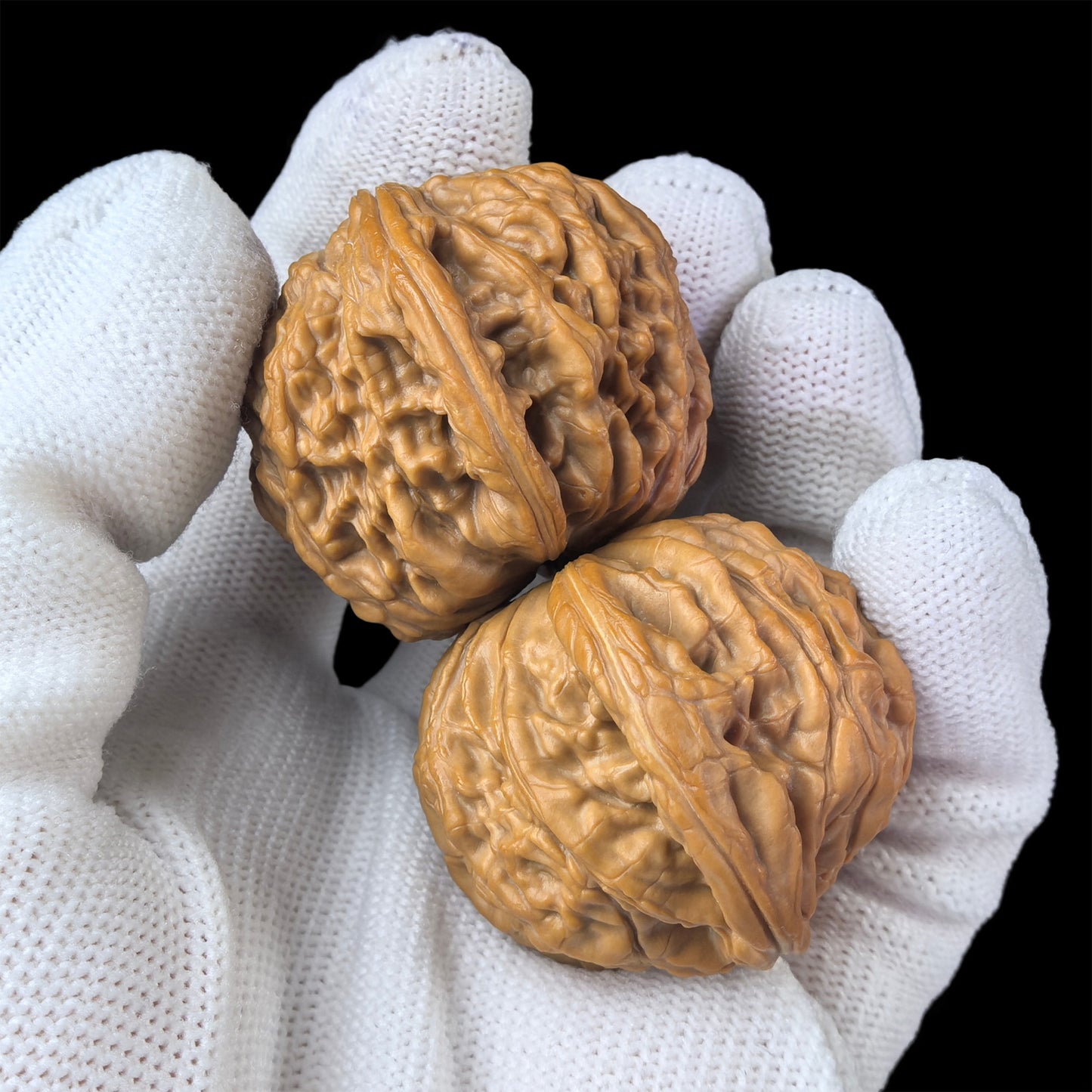 Walnut hand exerciser pair "Millstone" by ThePatinaProject, 40mm x 37mm, showing smooth walnut wood grips and textured surfaces.