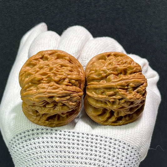 Pair of Walnut "Millstone" hand exercisers by ThePatinaProject, 40mm x 38mm, showing textured wooden grips for hand strengthening.