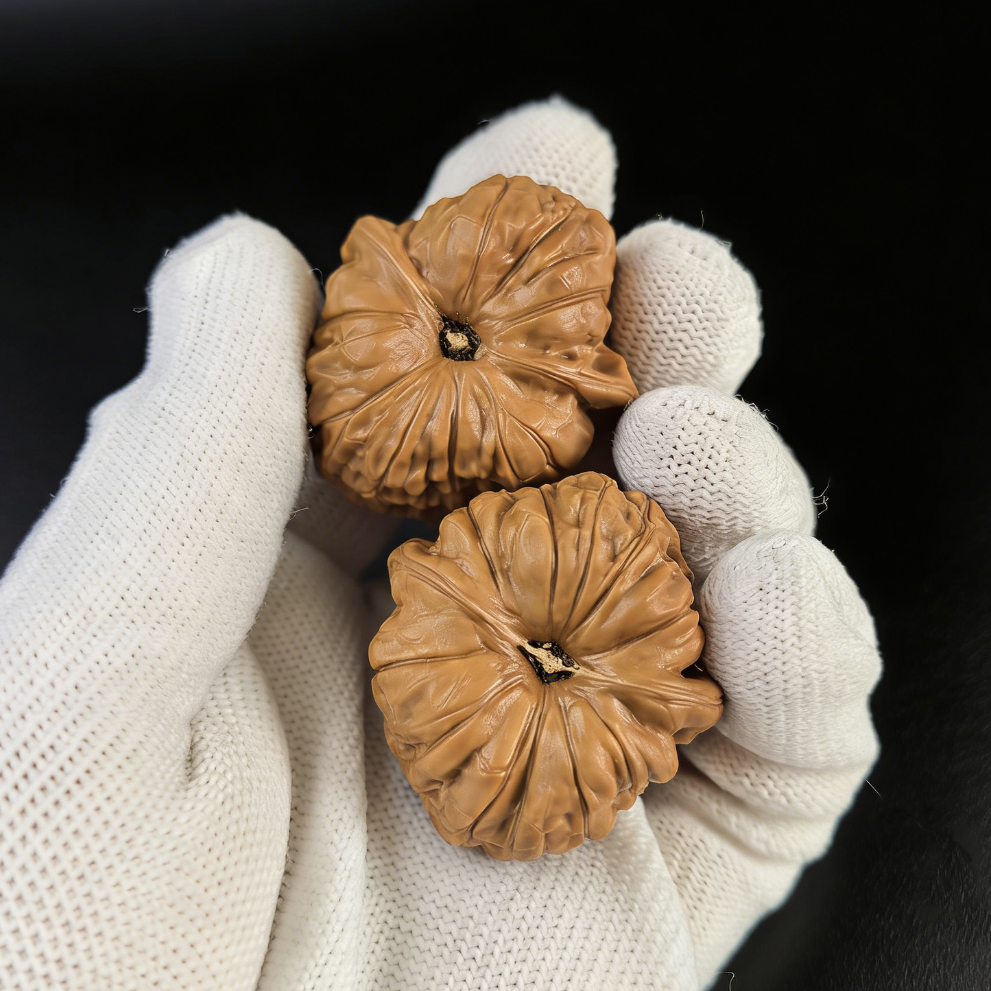 Walnut hand exerciser pair from ThePatinaProject, Little Pumpkin design, 37mm size, NGD-02, showing textured walnut surface.