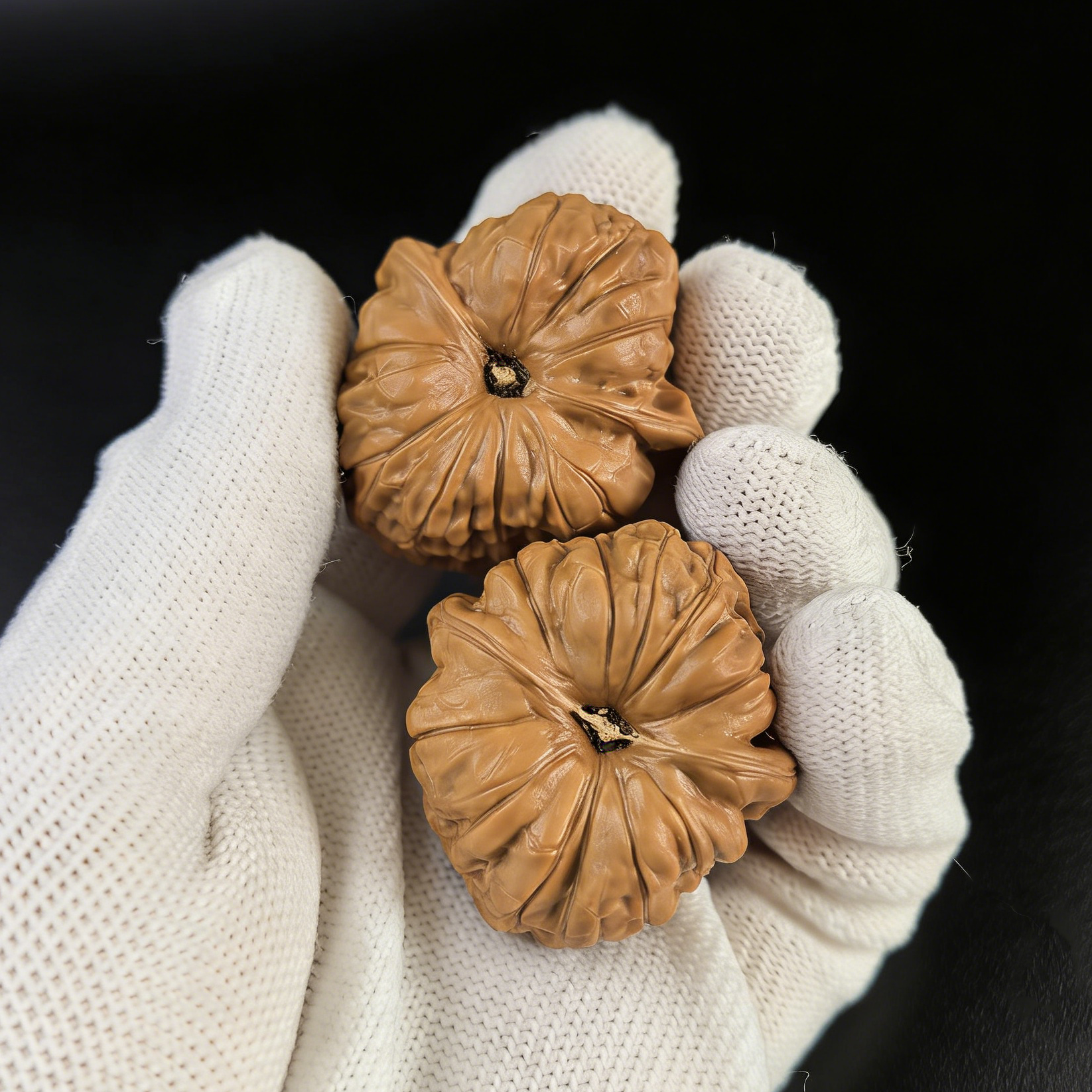 Walnut hand exerciser pair from ThePatinaProject, Little Pumpkin design, 37mm size, NGD-02, showing textured walnut surface.