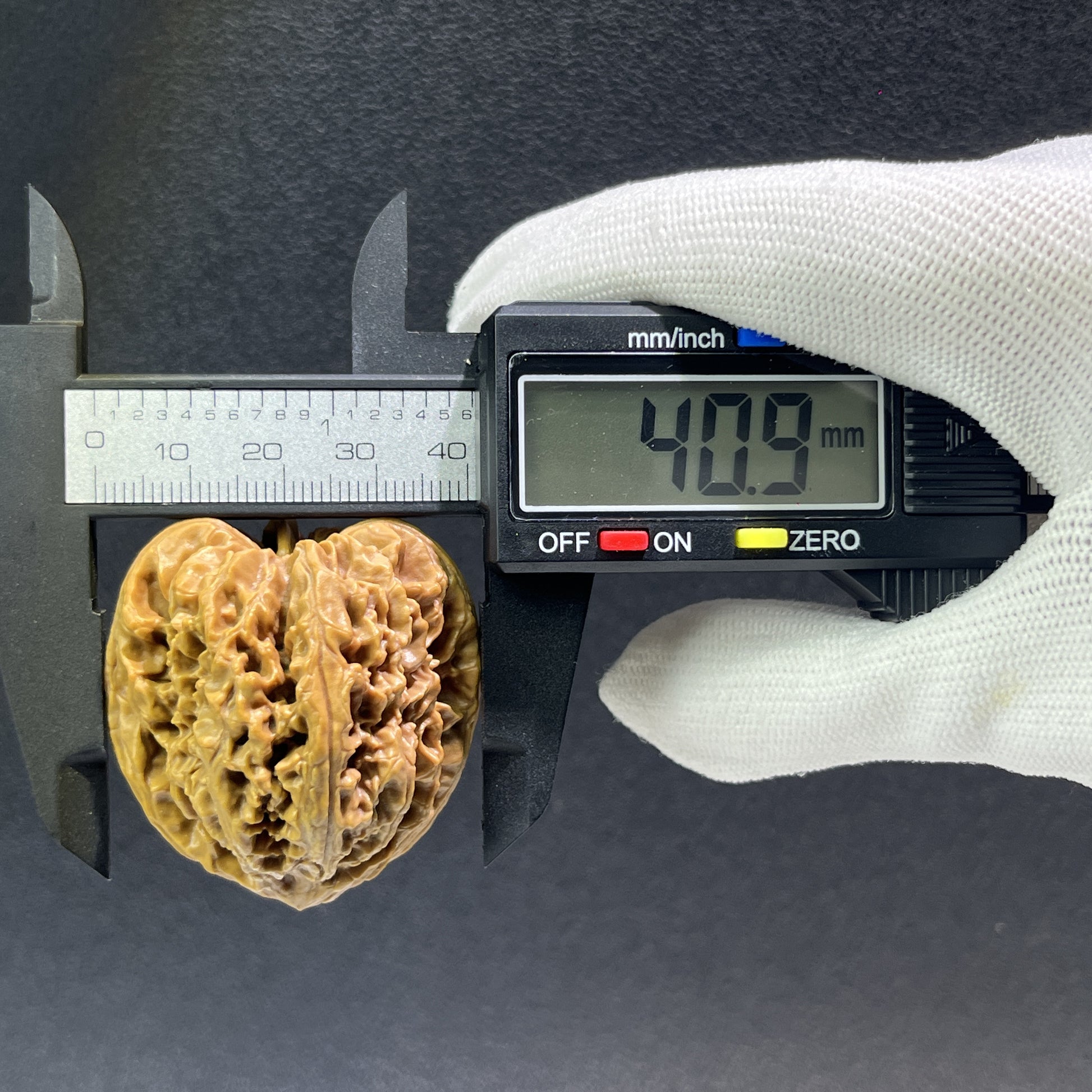 Walnut hand exerciser from ThePatinaProject, model NJS-405, measuring 41mm by 39mm, with a textured walnut finish.