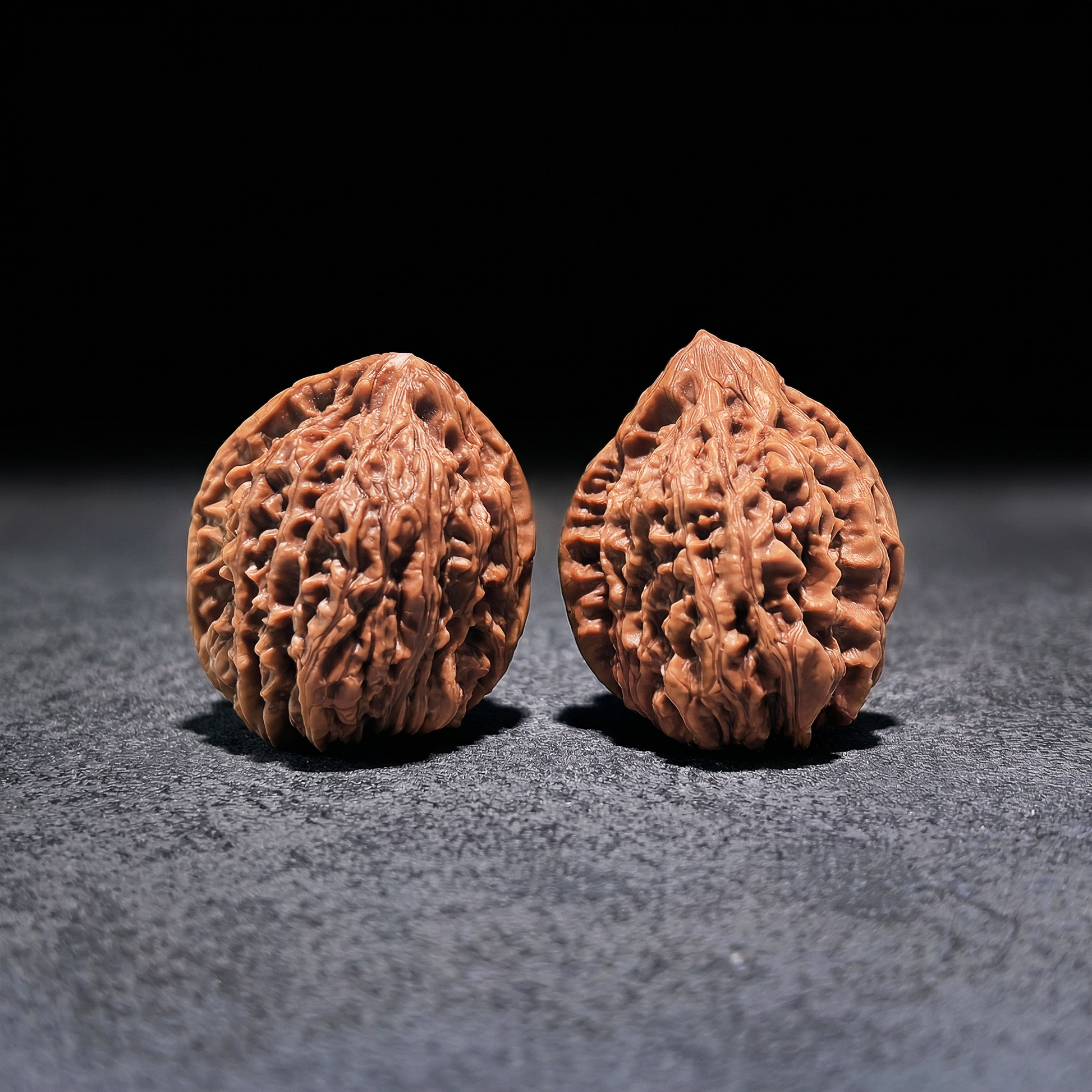 Pair of Nine Dragons Thick Ridge Walnut Hand Exercisers by ThePatinaProject, 40mm x 42mm, with textured ridged surface for grip.