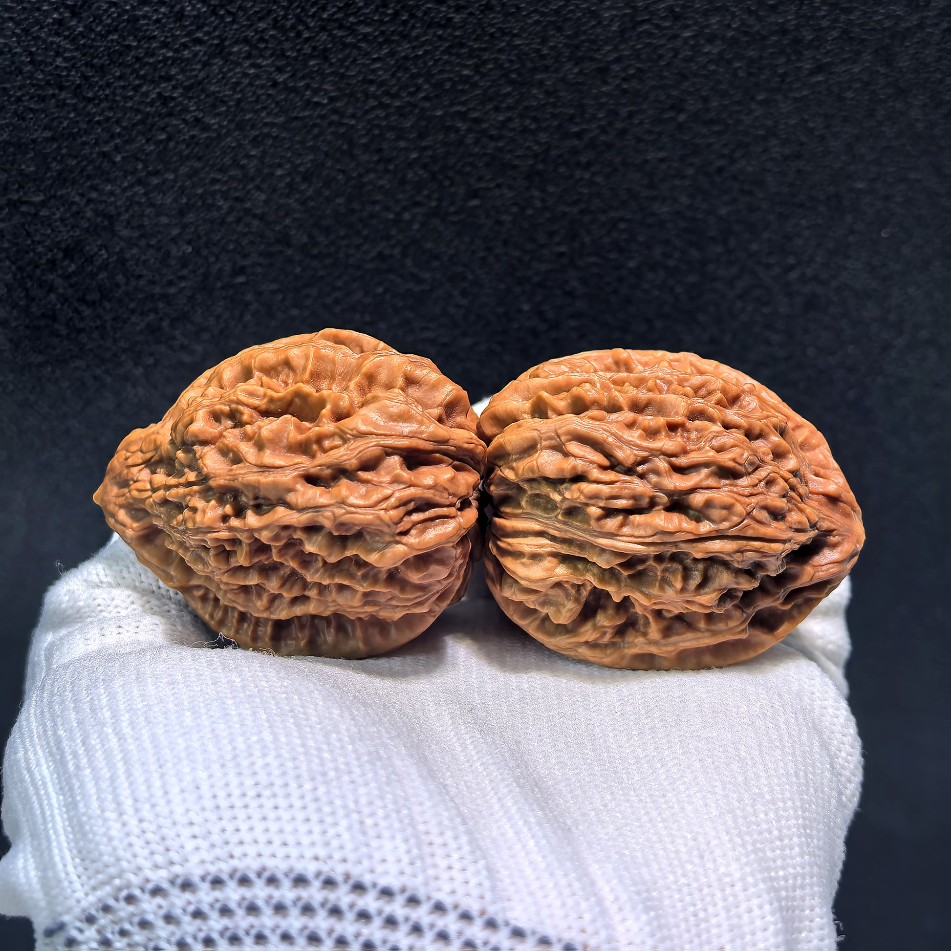 Pair of Nine Dragons Thick Ridge Walnut hand exercisers by ThePatinaProject, 40mm x 42mm, showing textured ridged surface for grip and strength.