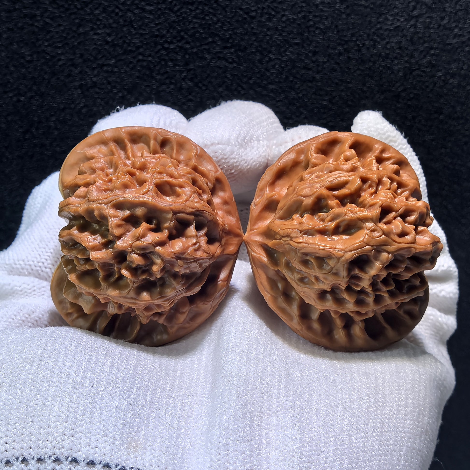 Pair of Palace Lantern walnut hand exercisers with intricate carvings, boutique grade, measuring 43mm x 39mm x 37mm.