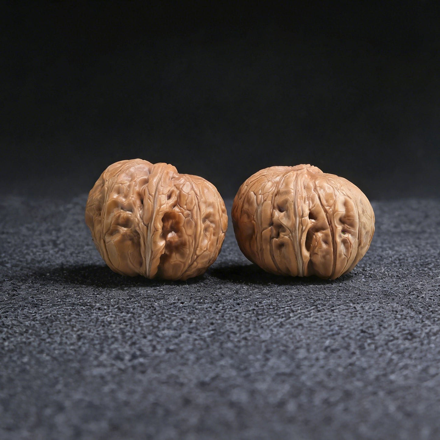 Pair of Pinggu "Ingot" walnut hand exercisers from ThePatinaProject, 35mm x 37mm, showcasing polished wooden grips and ergonomic design.