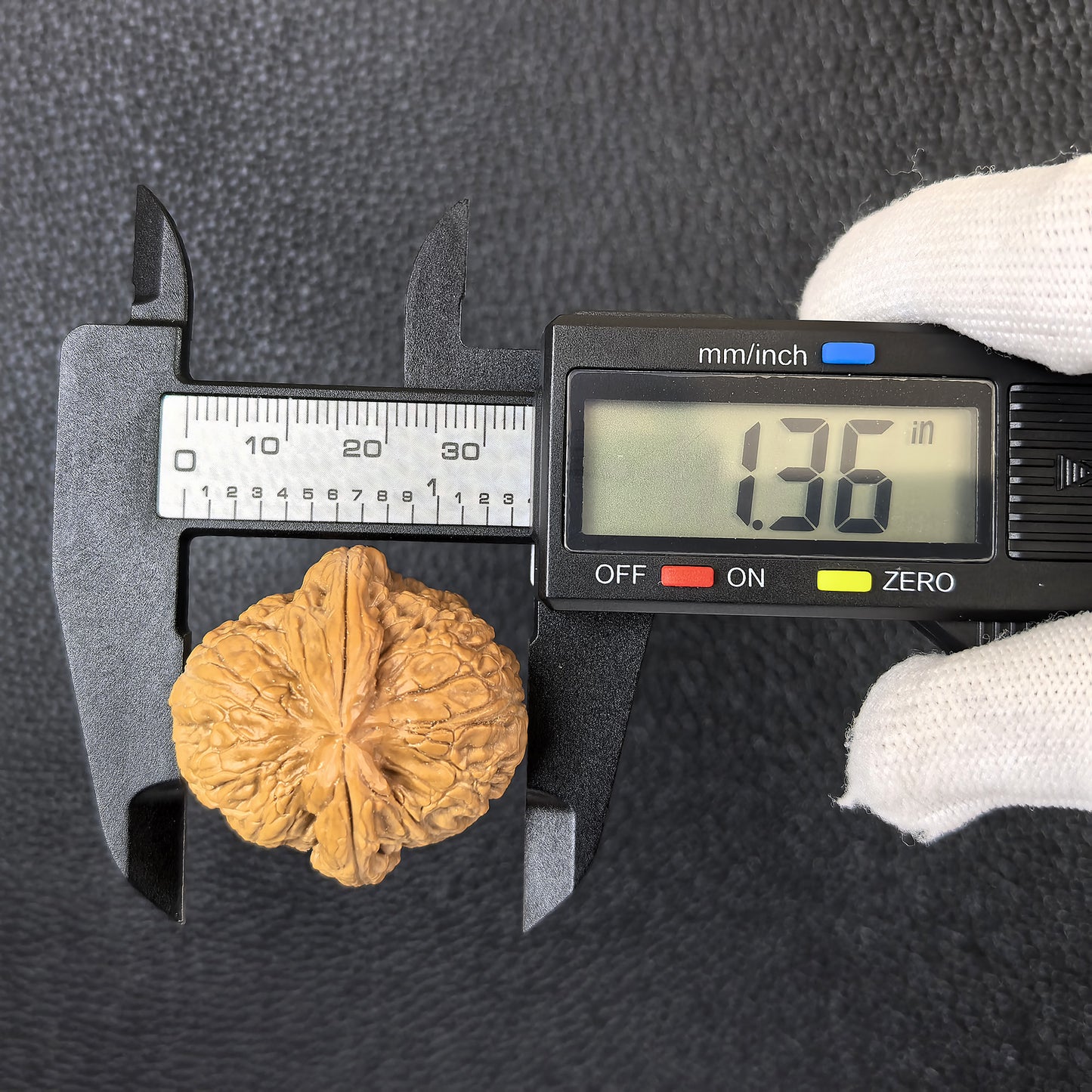 Pair of Pinggu Ingot walnut hand exercisers from ThePatinaProject, 33mm x 34mm, with detailed carved design.
