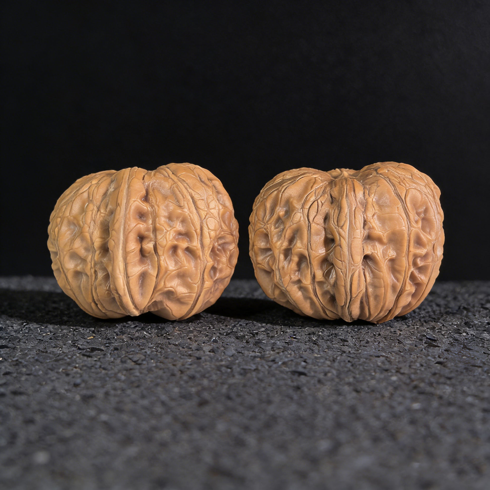 Pair of Pinggu Ingot walnut hand exercisers from ThePatinaProject, 33mm x 37mm, with smooth polished surfaces and traditional design.
