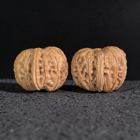 Pair of Pinggu Ingot walnut hand exercisers from ThePatinaProject, 33mm x 37mm, with smooth polished surfaces and traditional design.