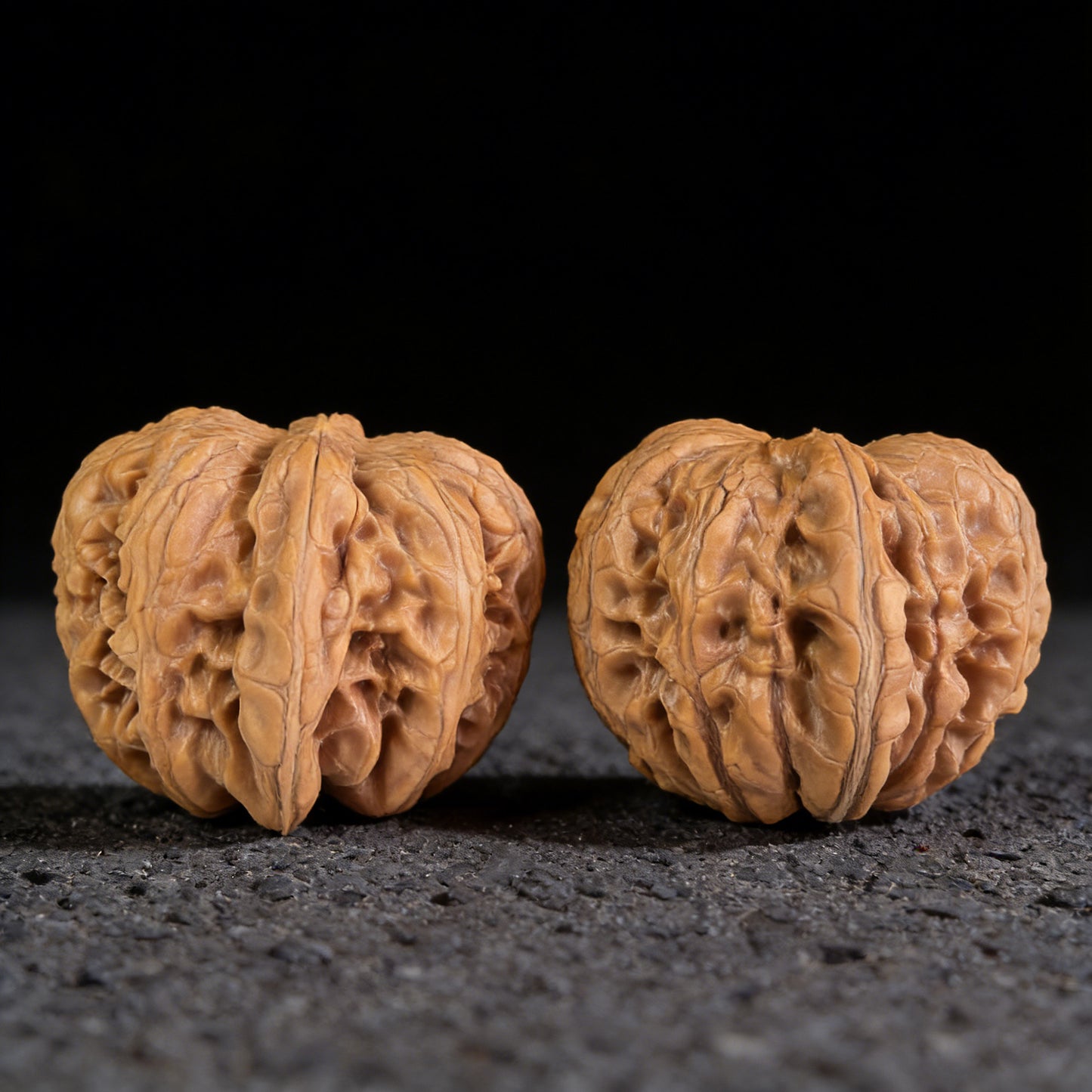 Pair of Pinggu Ingot walnut hand exercisers by ThePatinaProject, 39mm x 42mm, featuring intricate carved designs for grip and exercise.