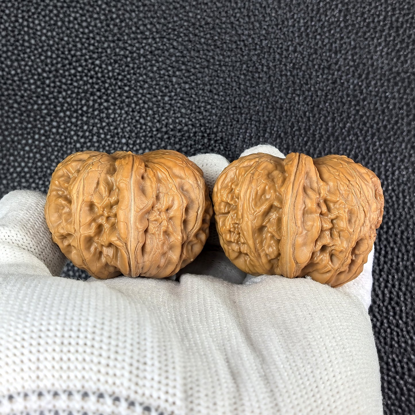Pair of Pinggu Ingot walnut hand exercisers from ThePatinaProject, 39mm x 42mm, with intricate carved patterns.
