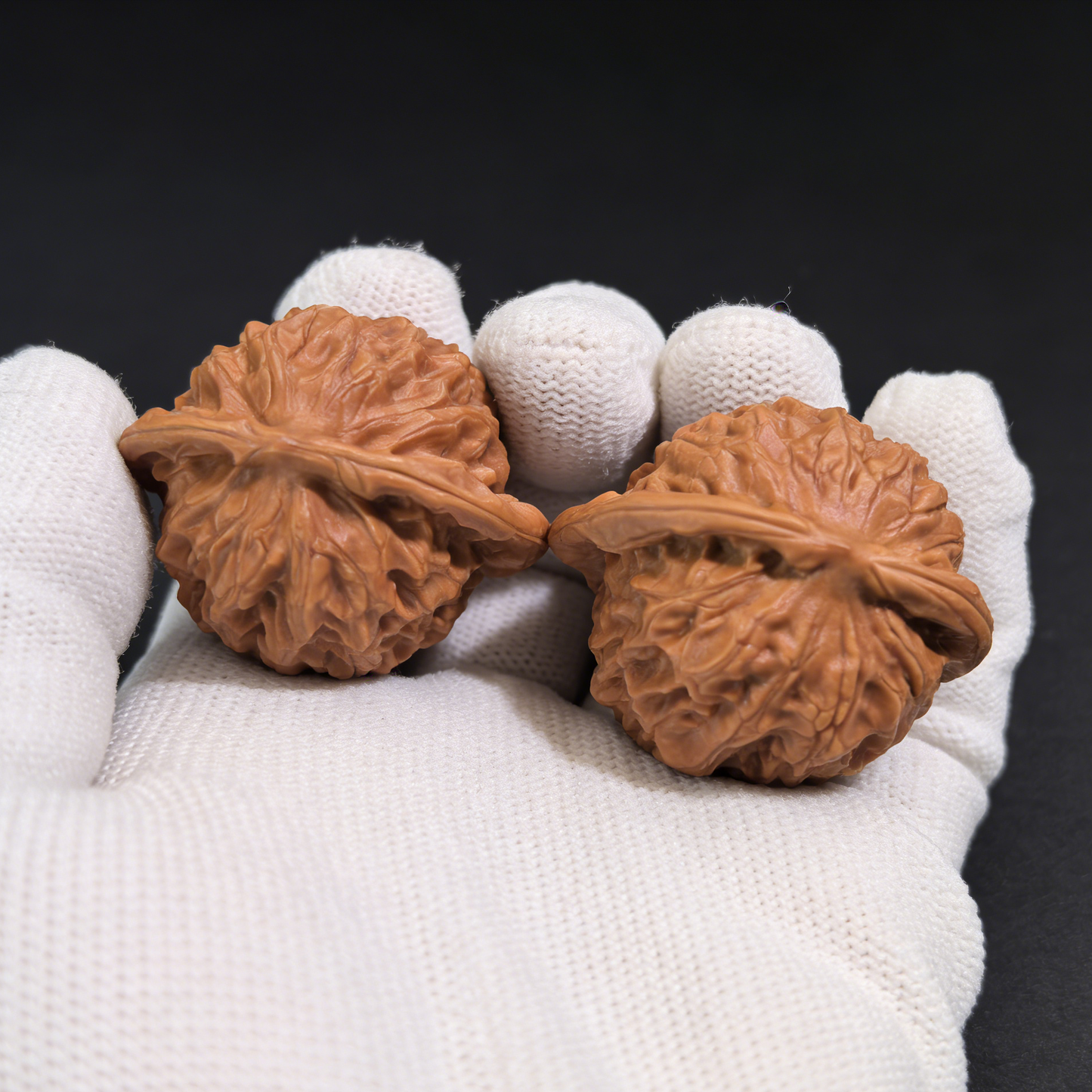 Pair of walnut hand exercisers with porcelain doll design, featuring refined elegance and waxy luster, 38mm collector’s size.