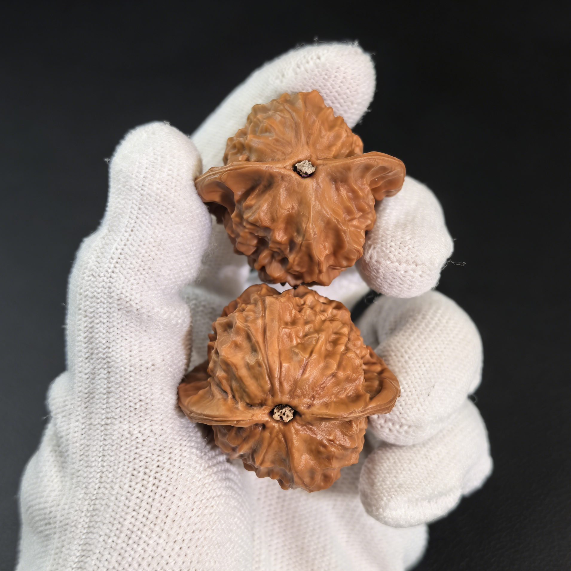 Walnut hand exerciser with porcelain doll design, waxy luster finish, 38mm diameter, by ThePatinaProject, part of collector’s pair