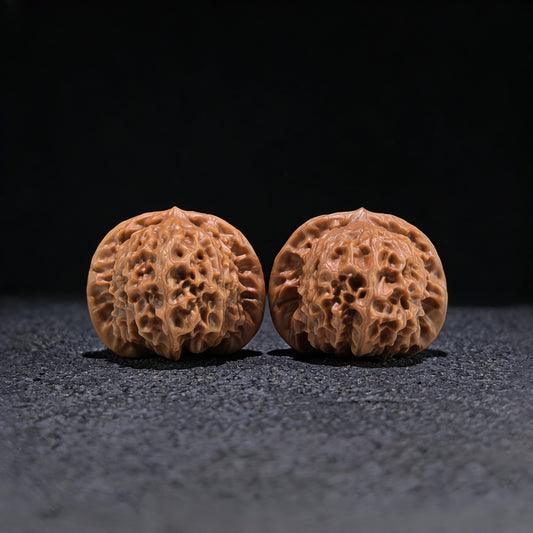 Walnut hand exercisers featuring porcelain doll and Guan Yin seal, boutique grade, with detailed engravings and smooth finish.
