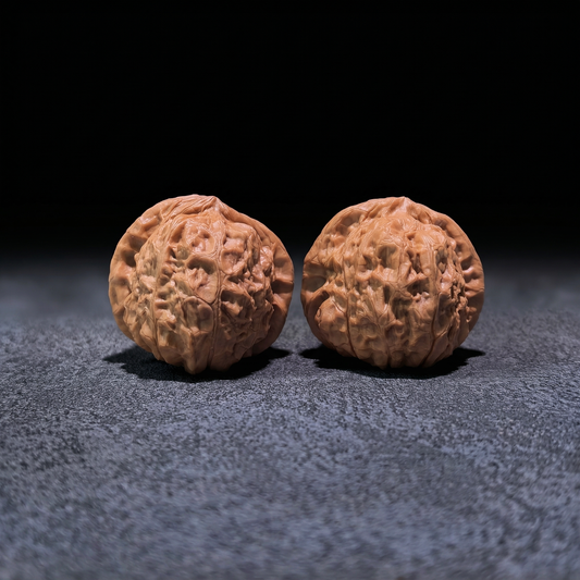 Walnut hand exerciser pair "Pumpkin Squat" by ThePatinaProject, 42mm x 42mm, showing textured walnut surface for grip and exercise.