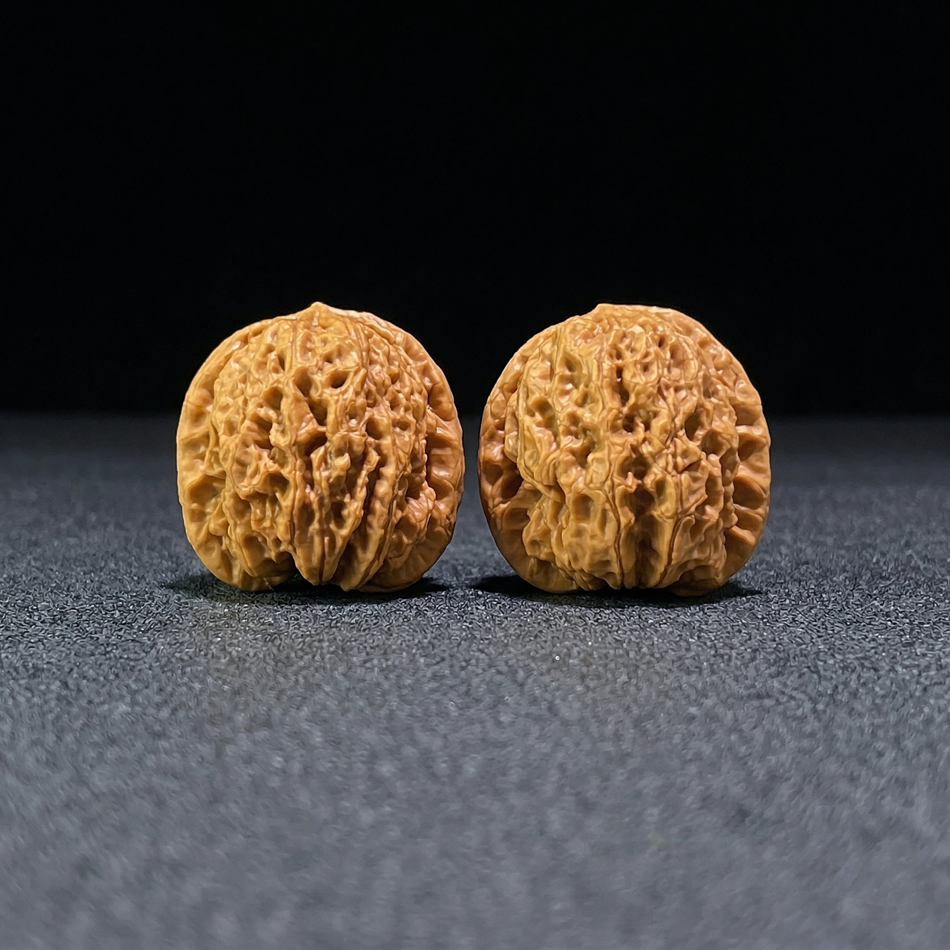 Walnut hand exerciser pair labeled YHS-601, Rain Flower Pebble design, 34mm x 31mm, from ThePatinaProject, natural textured surface