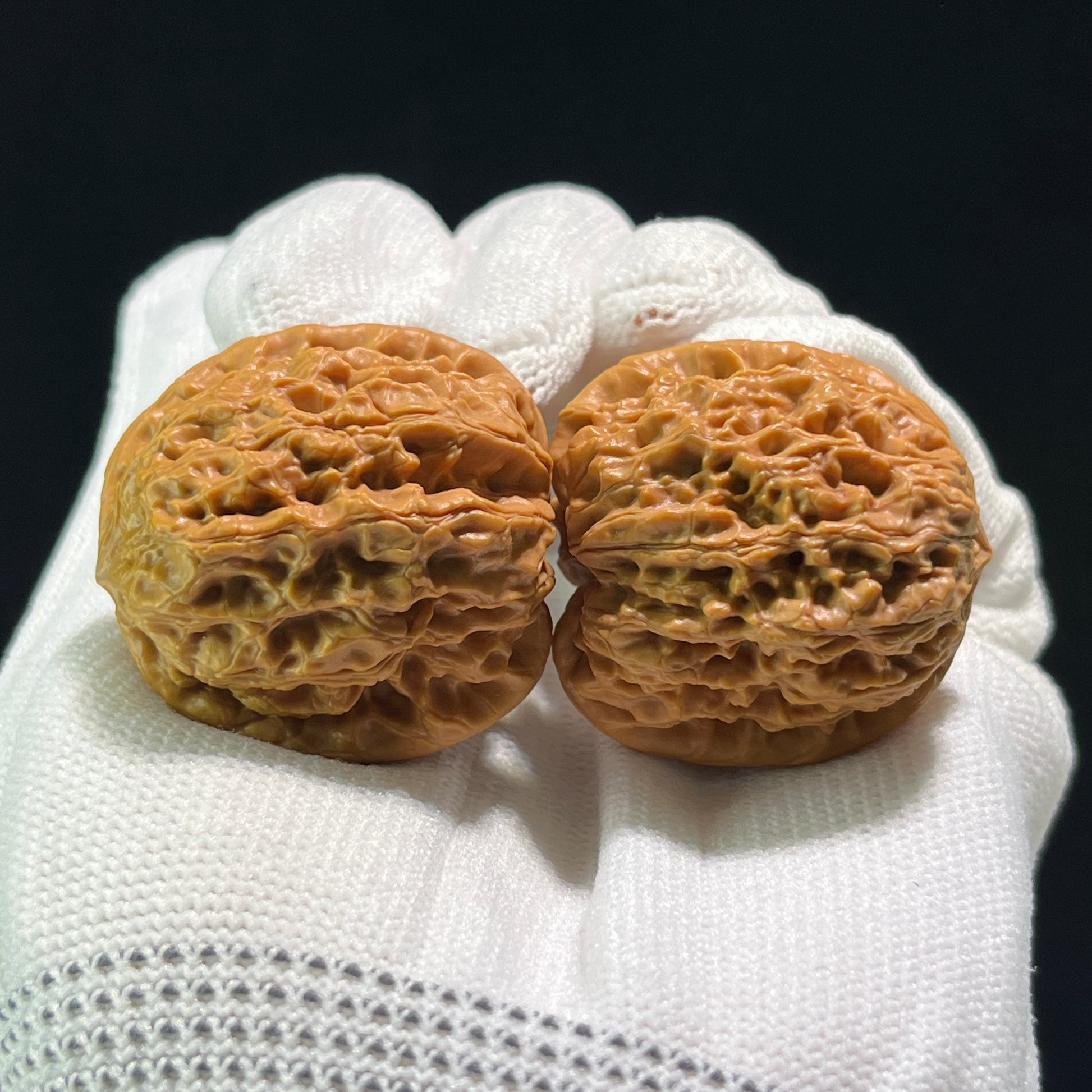 Pair of Walnut Hand Exercisers, Rain Flower Pebble design, ThePatinaProject YHS-601, 34mm x 31mm, natural wood finish.