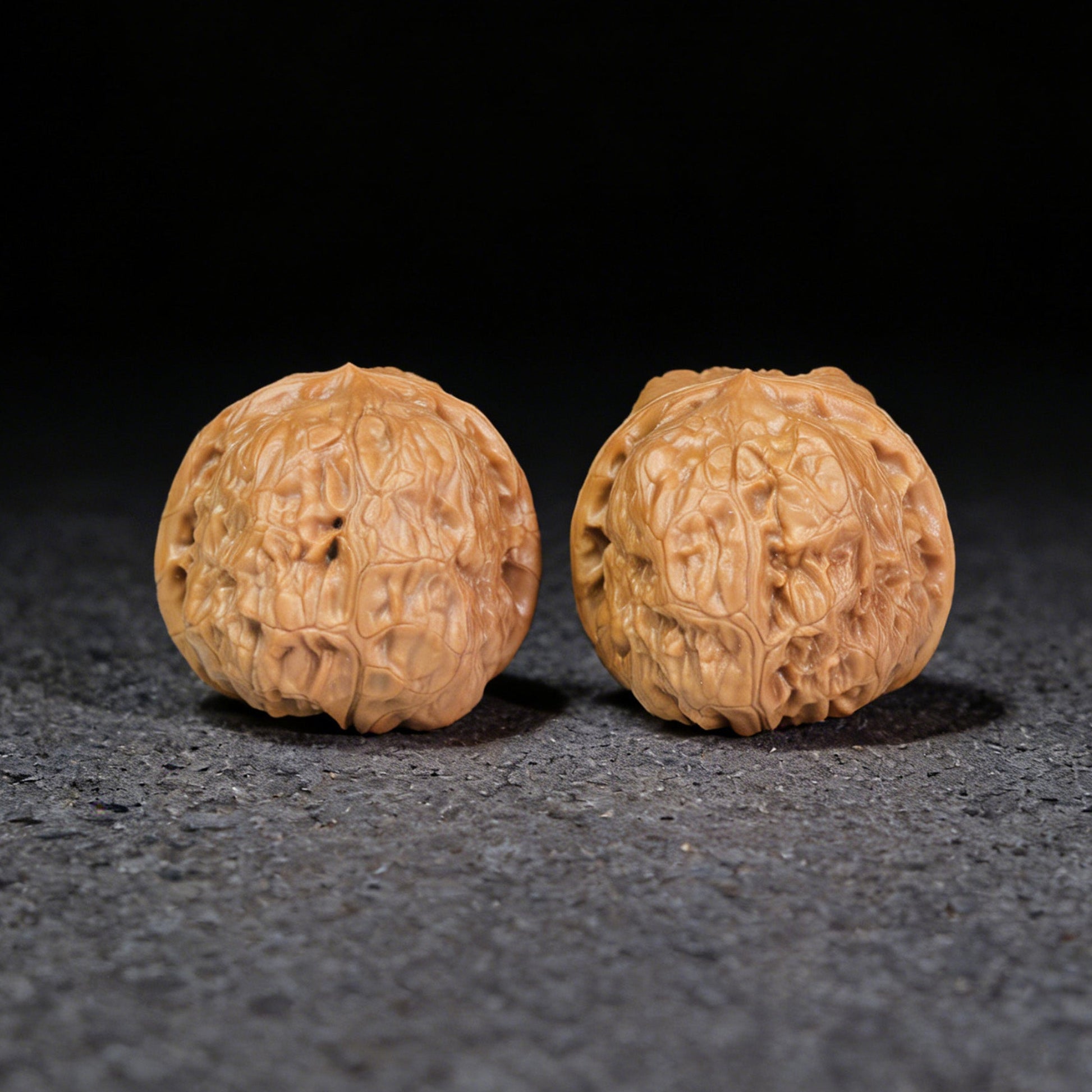 Pair of Walnut Hand Exercisers with red square seals, 38mm x 43mm, from ThePatinaProject, showcasing detailed craftsmanship and natural wood grain.