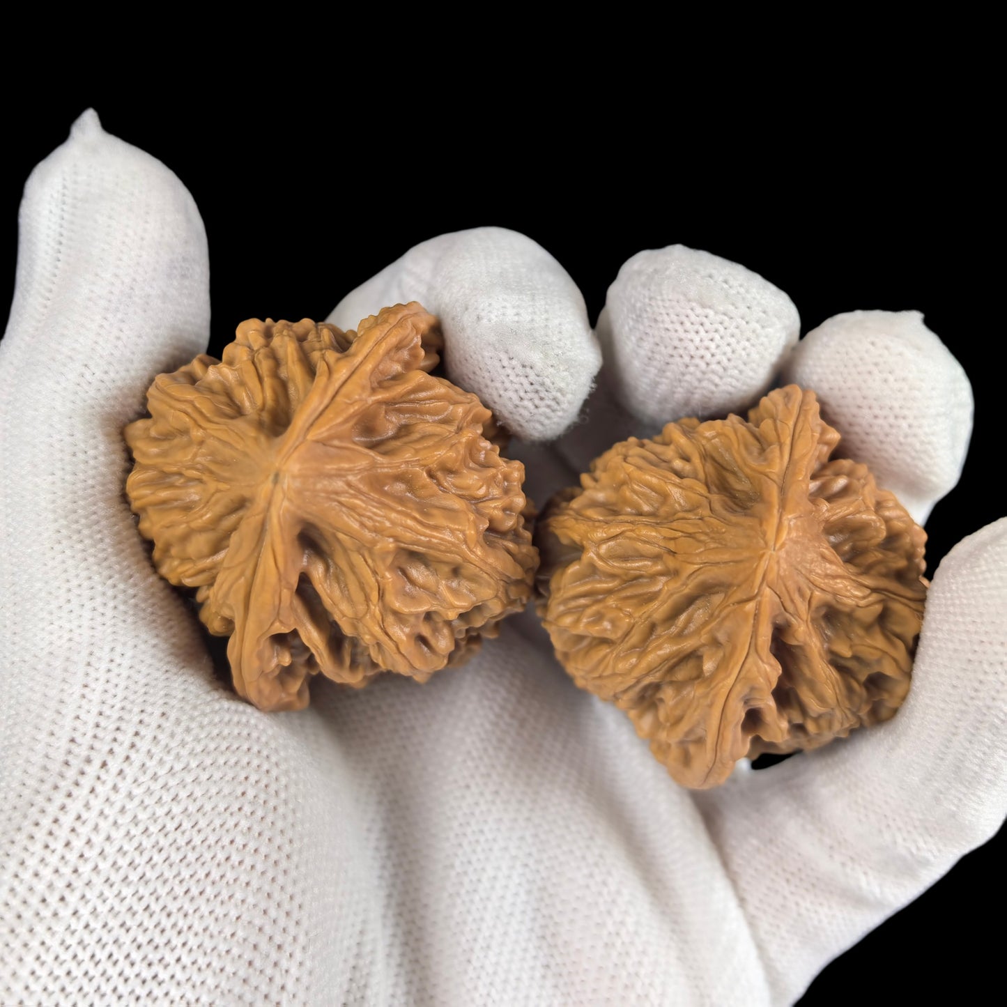 Walnut hand exercisers from ThePatinaProject, "Seven Mountains" QS-01 pair, 35mm size, showing textured wooden grip and natural finish.