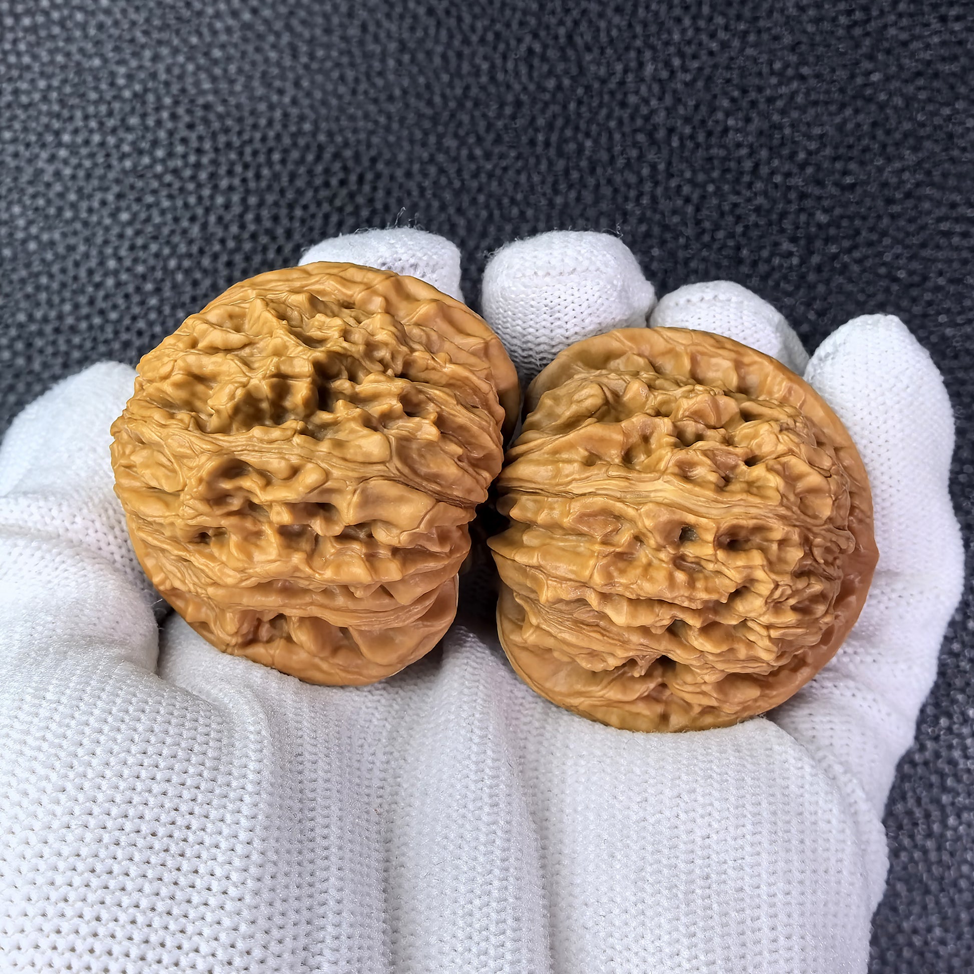 Pair of Walnut "Si Zuo Lou" lion head hand exercisers by ThePatinaProject, 41mm diameter, featuring detailed carved lion head designs.