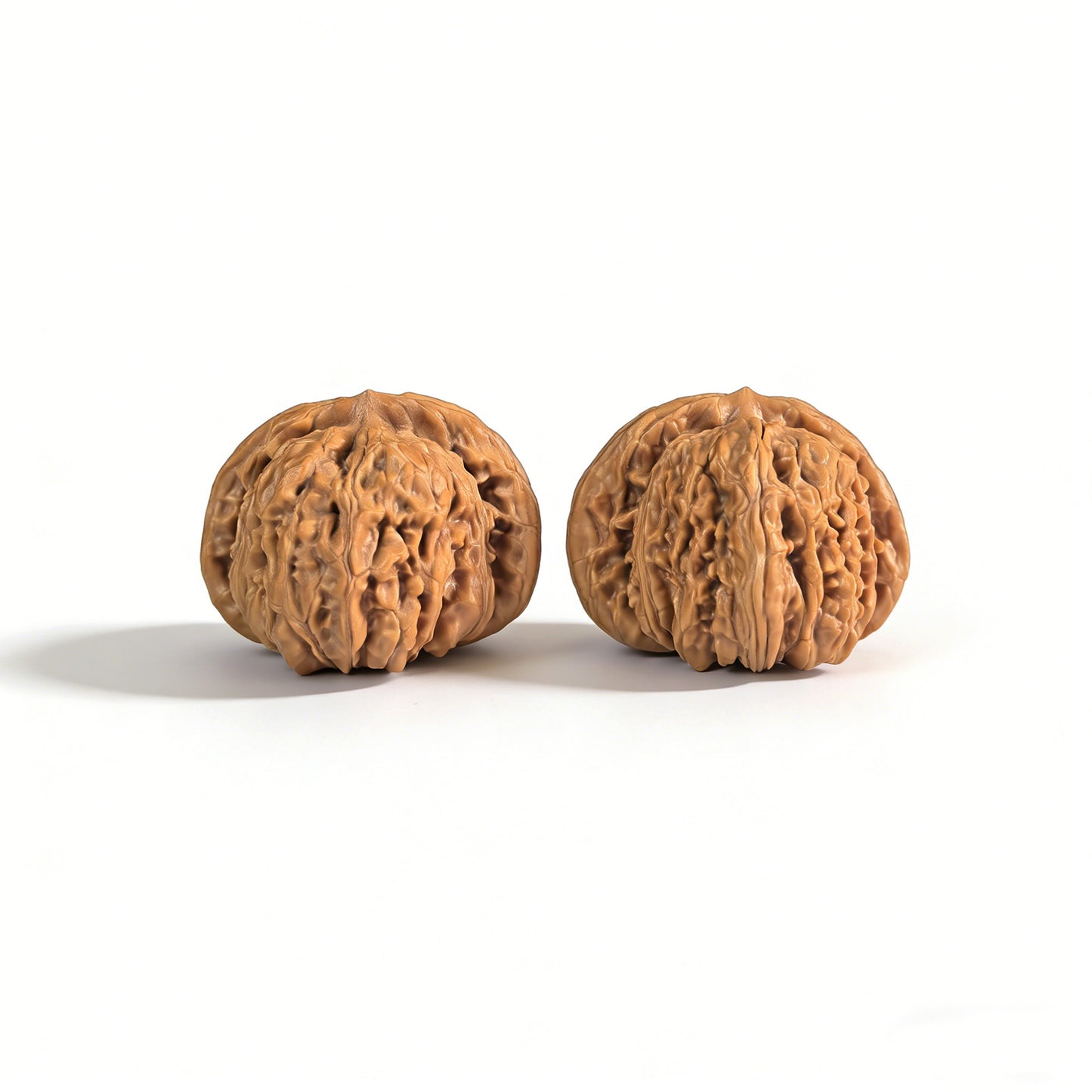 Pair of walnut lion head hand exercisers from ThePatinaProject, 43mm x 40mm, with detailed carved lion head designs.