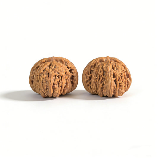 Pair of walnut lion head hand exercisers from ThePatinaProject, 43mm x 40mm, with detailed carved lion head designs.