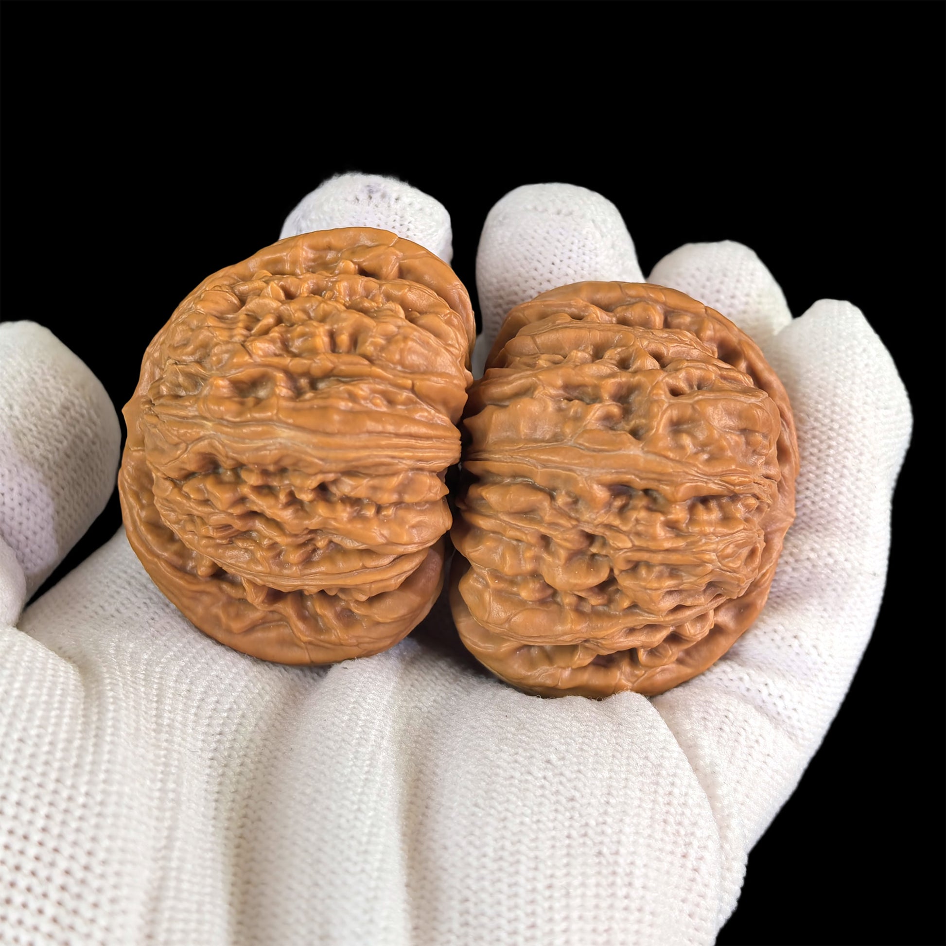 Pair of walnut lion head hand exercisers from ThePatinaProject, 43mm x 40mm, featuring detailed carved lion head designs.