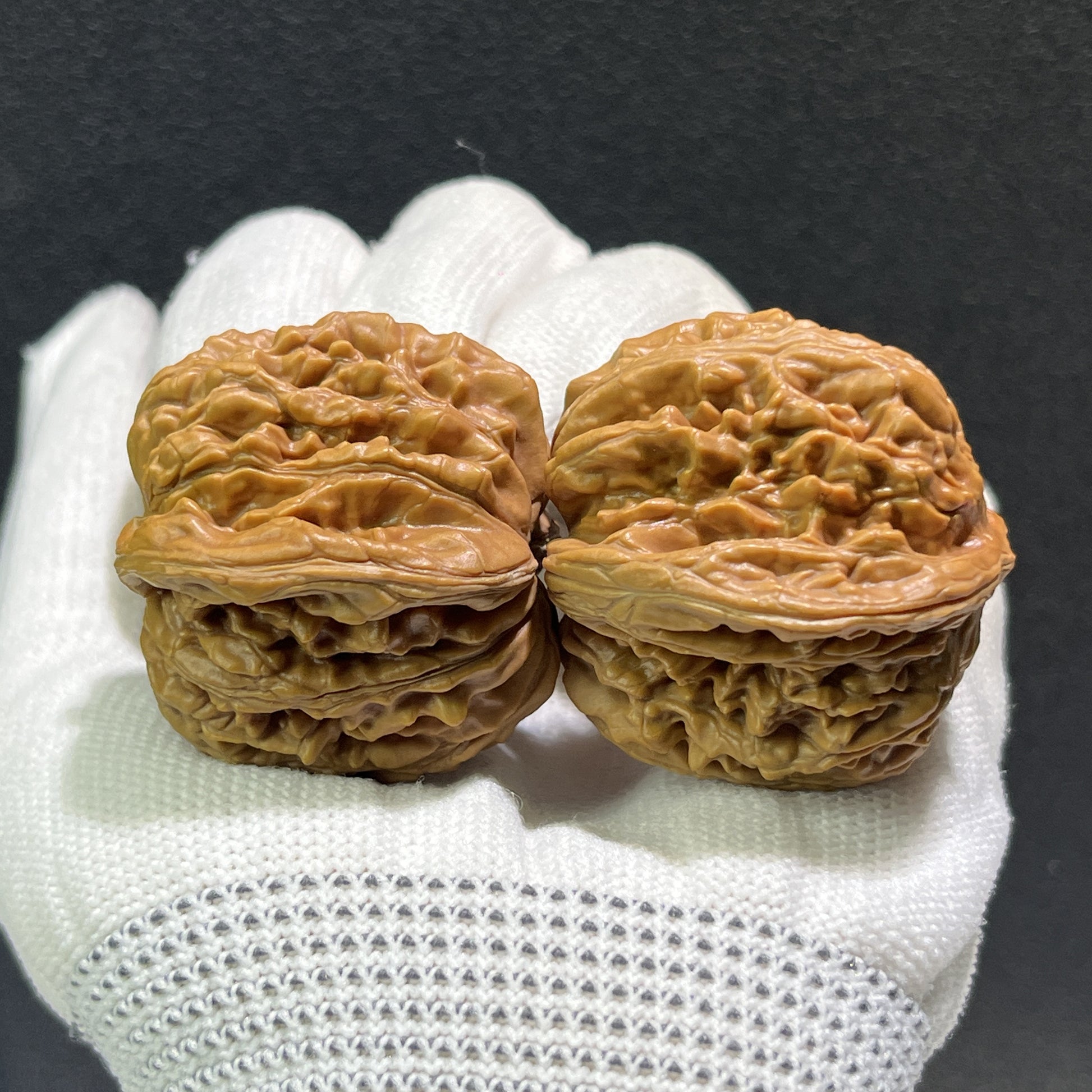 Pair of walnut lion's head hand exercisers from ThePatinaProject, 38mm size, featuring detailed carved lion's head designs.