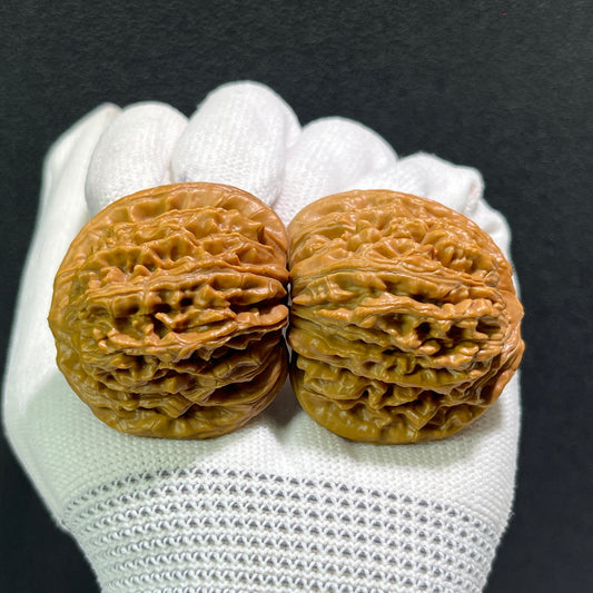 Pair of Walnut Lion's Head hand exercisers, 40mm x 36mm, from ThePatinaProject's Si Zuo Lou collection, featuring detailed carved lion heads.